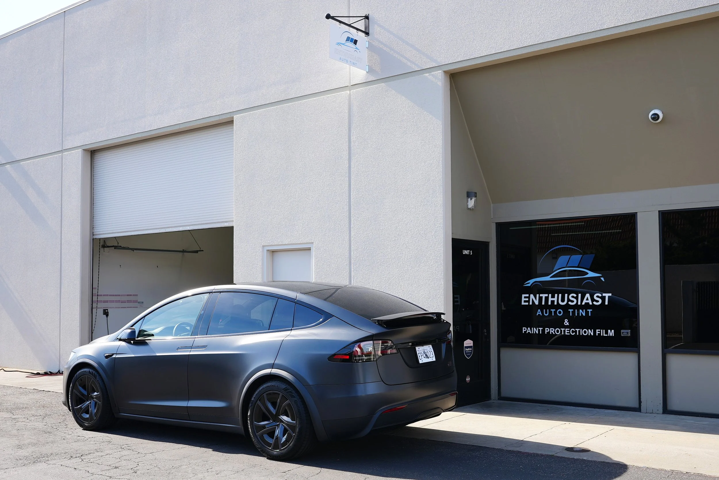 Silver Tesla parked outside Enthusiast Auto Tint & Paint Protection Film shop in Campbell, representing premium Tesla ceramic window tint, paint protection film, and ceramic coating services for luxury and electric vehicles.