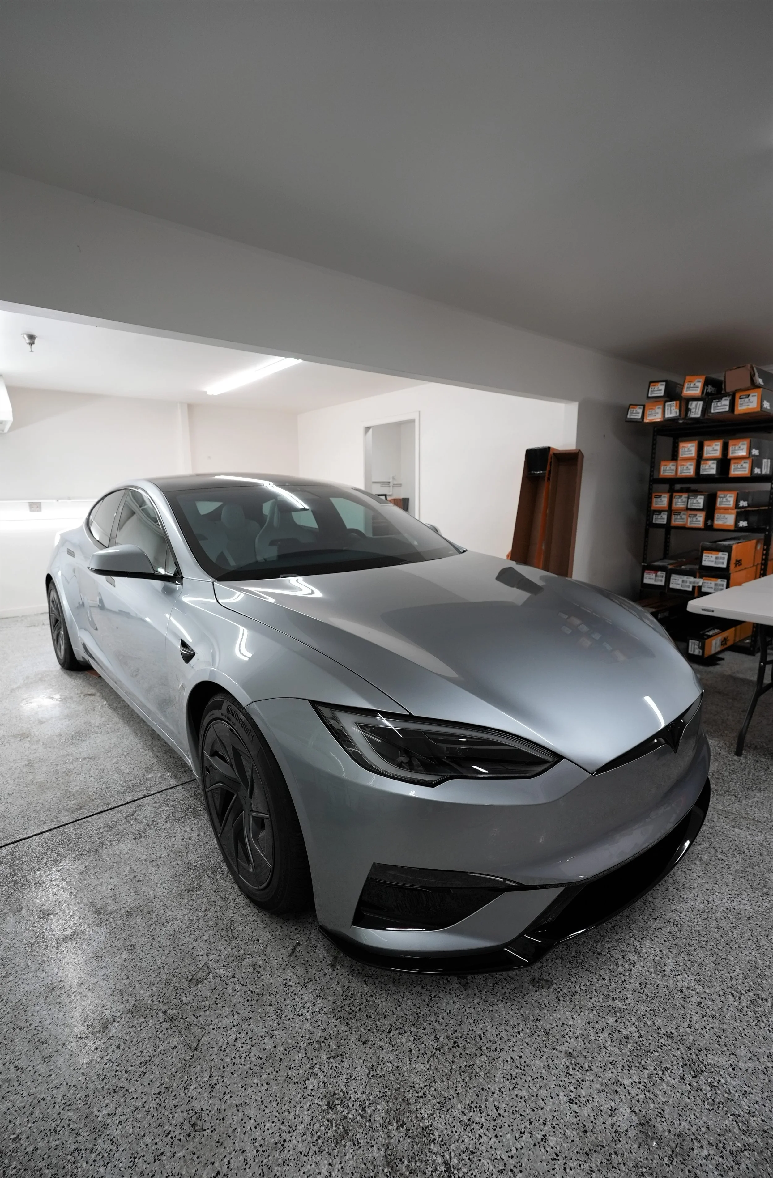 Silver modern sports car in a premium indoor garage in Campbell, showcasing luxury vehicle protection services including ceramic window tint, paint protection film, and ceramic coating by Enthusiast Auto Tint.