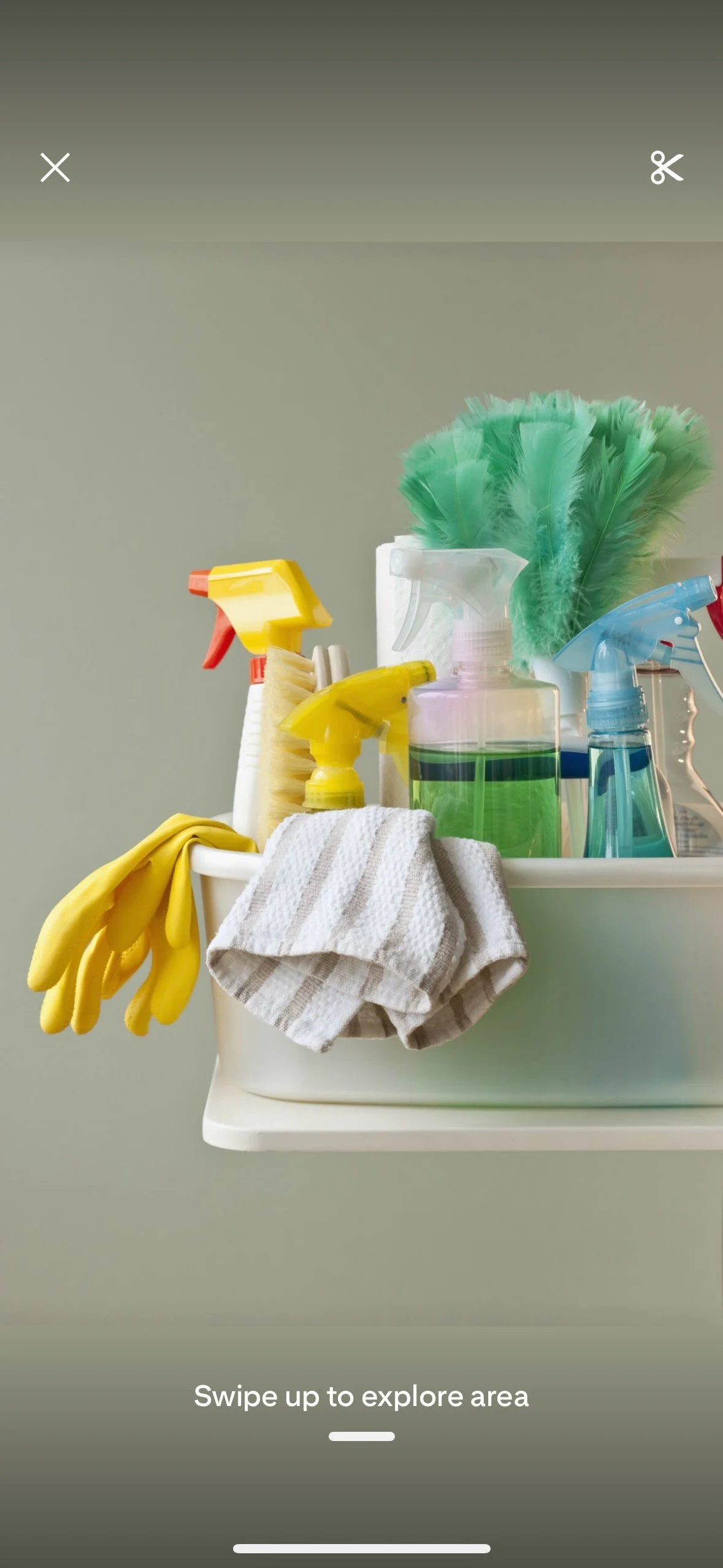 Cleaning supplies including spray bottles, gloves, a scrub brush, a microfiber cloth, and a cleaning cloth in a white container with a pale green background.