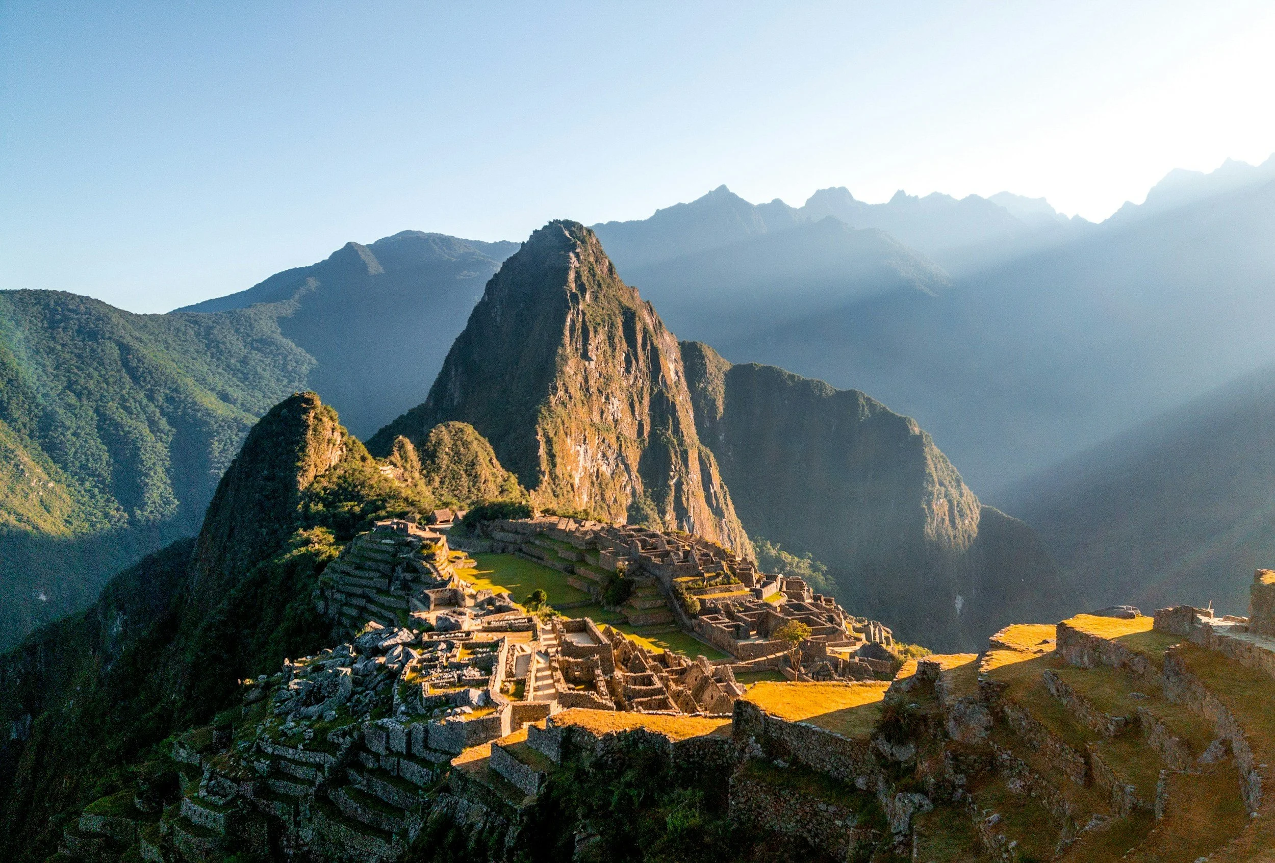 Ancient Incan city Machu Picchu with terraced fields and steep mountain backdrop in Peru