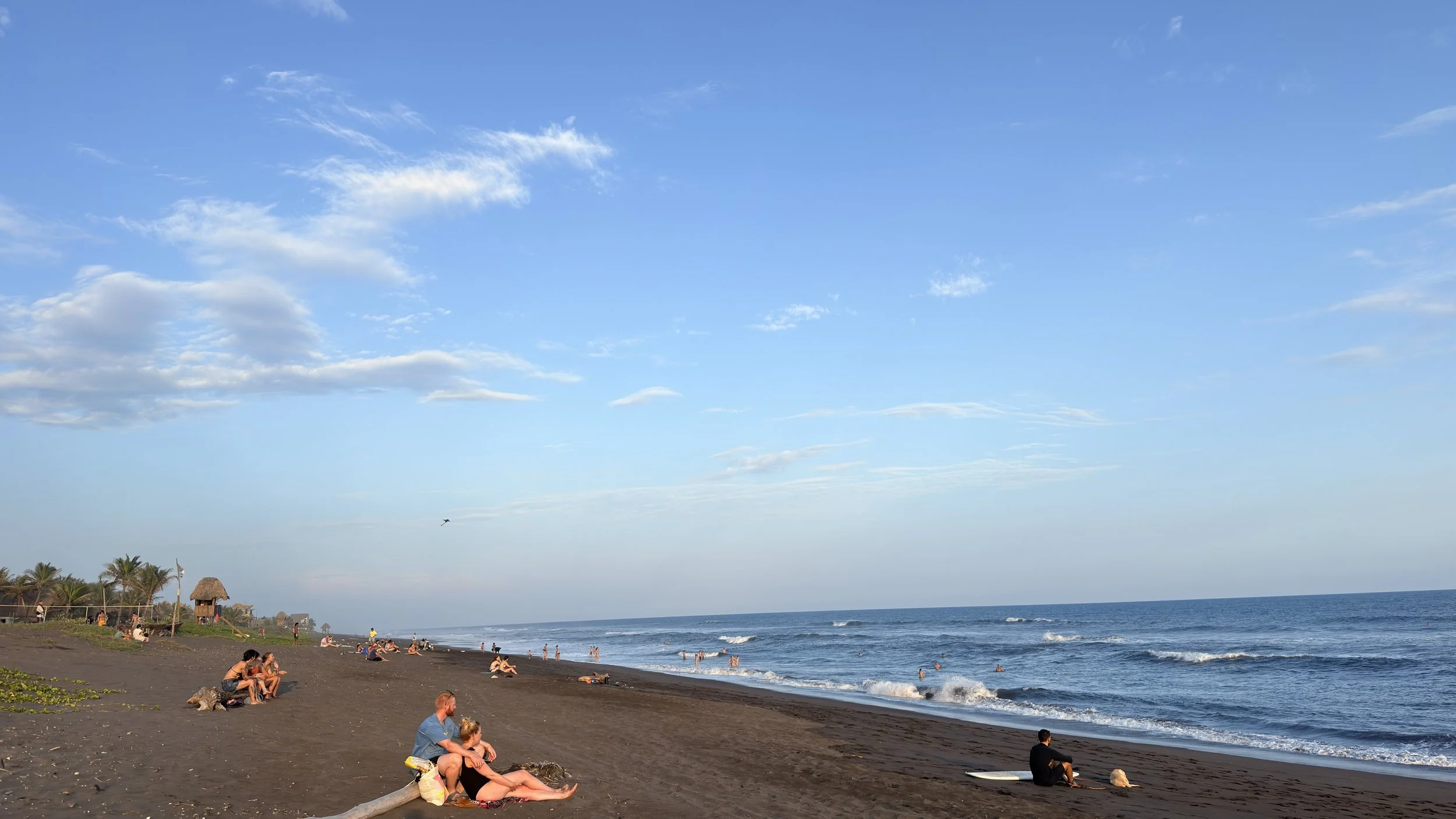 Black sand beach and Pacific surf at sunset in El Paredón, Guatemala