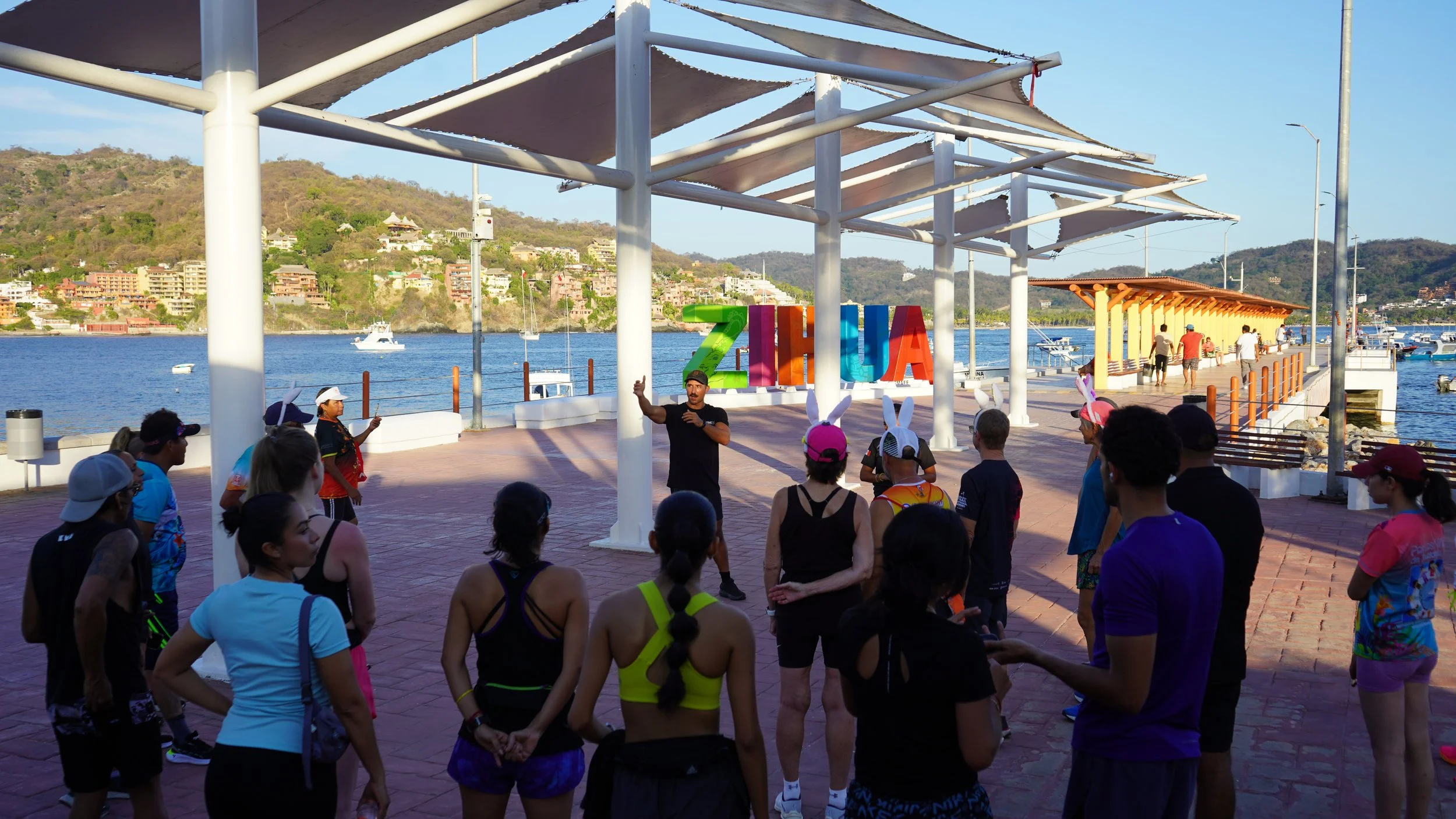 Man with mustache at muelle of zihuatanejo surrounded by team of 30 runners for first community run of zihrc