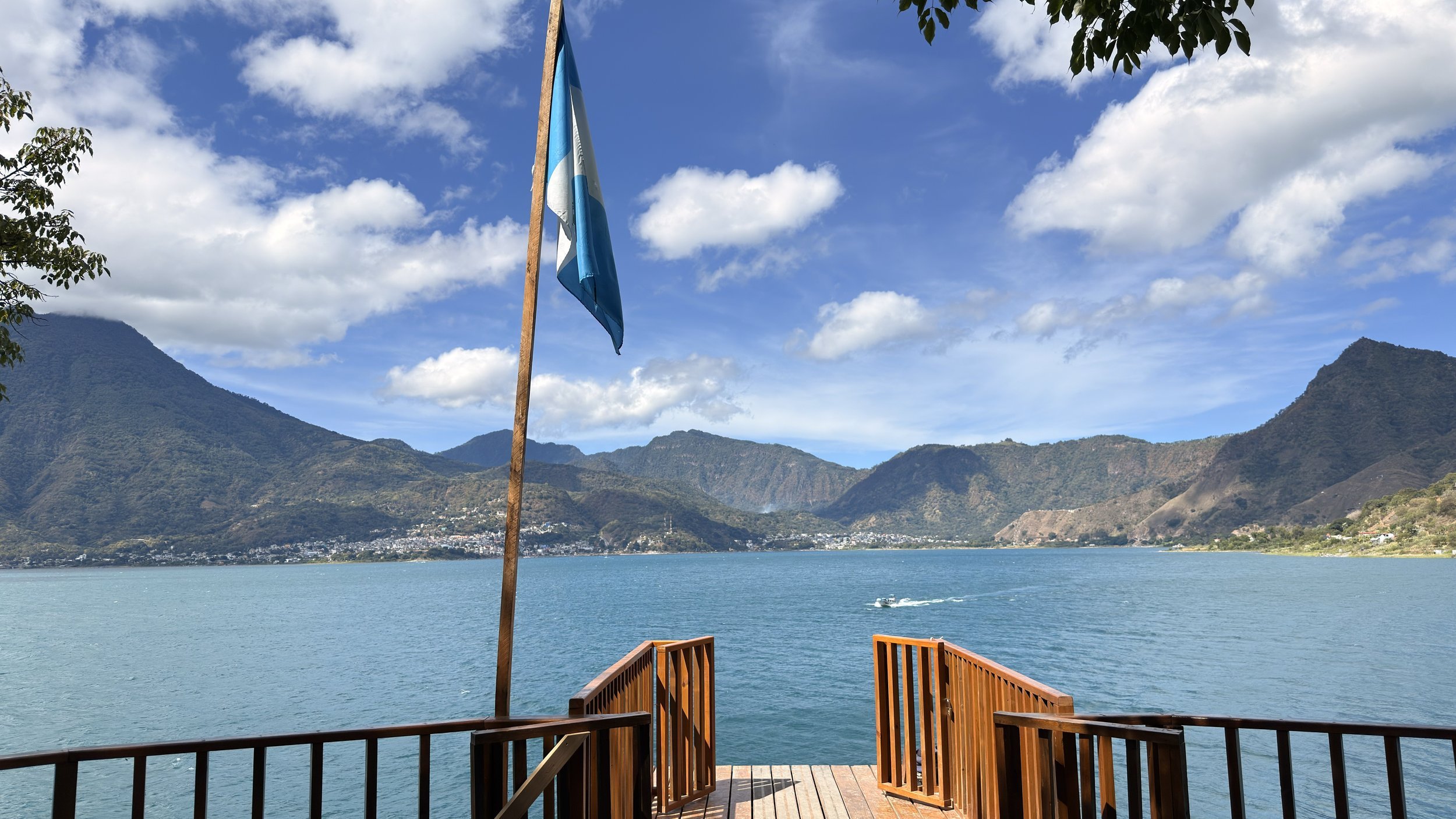 Wooden cliff-jumping platform with a Guatemalan flag at Reserva Natural Cerro Tzankujil on Lake Atitlán