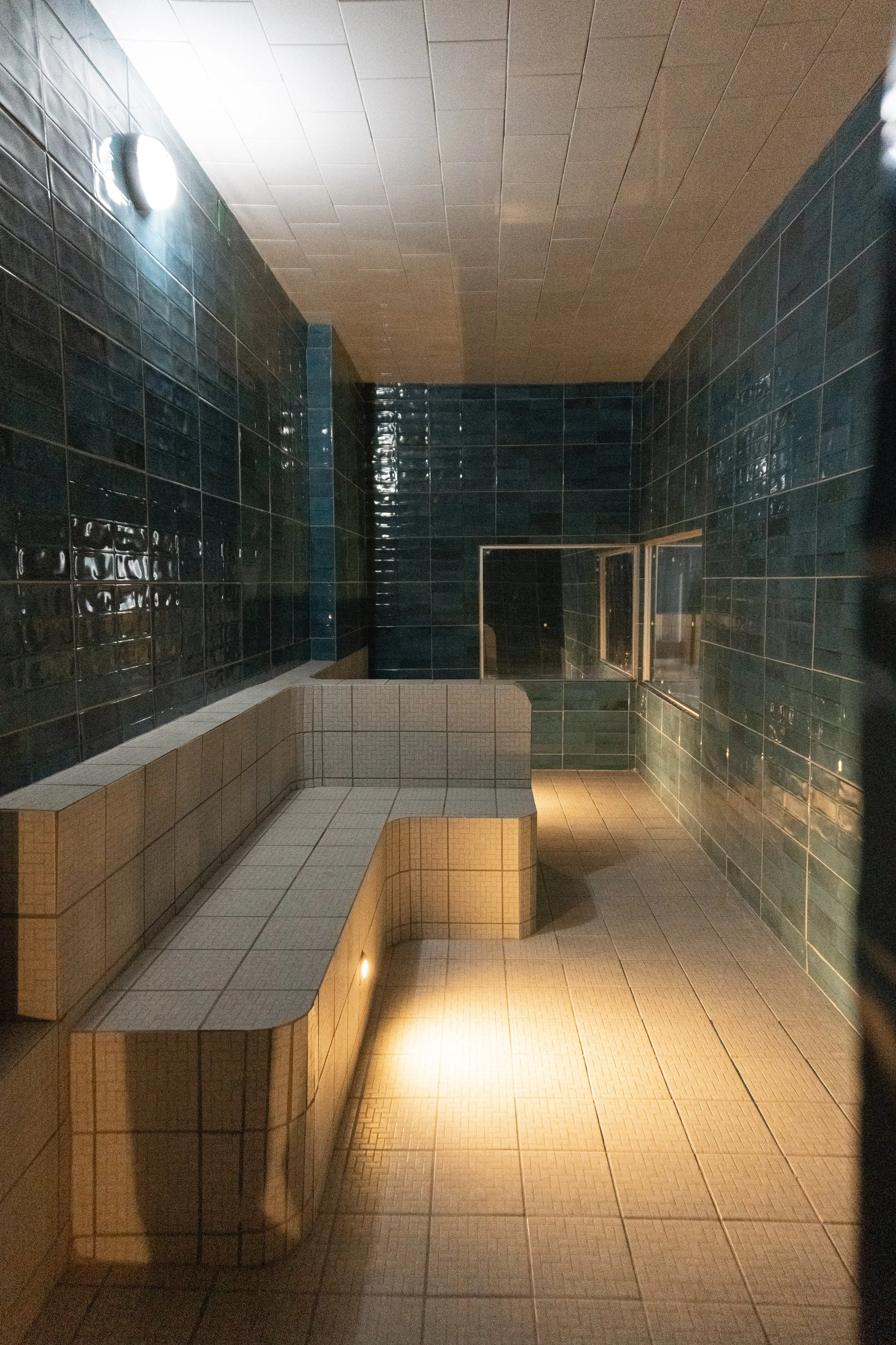 Cuarto de vapor nivel bajo con paredes de azulejos, iluminación tenue con algunas luces montadas en la pared en Polari, el mejor sauna en el centro de Guadalajara