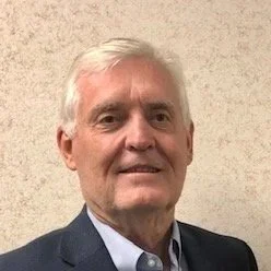 Portrait of Benton Clark smiling at the camera and wearing a suit.