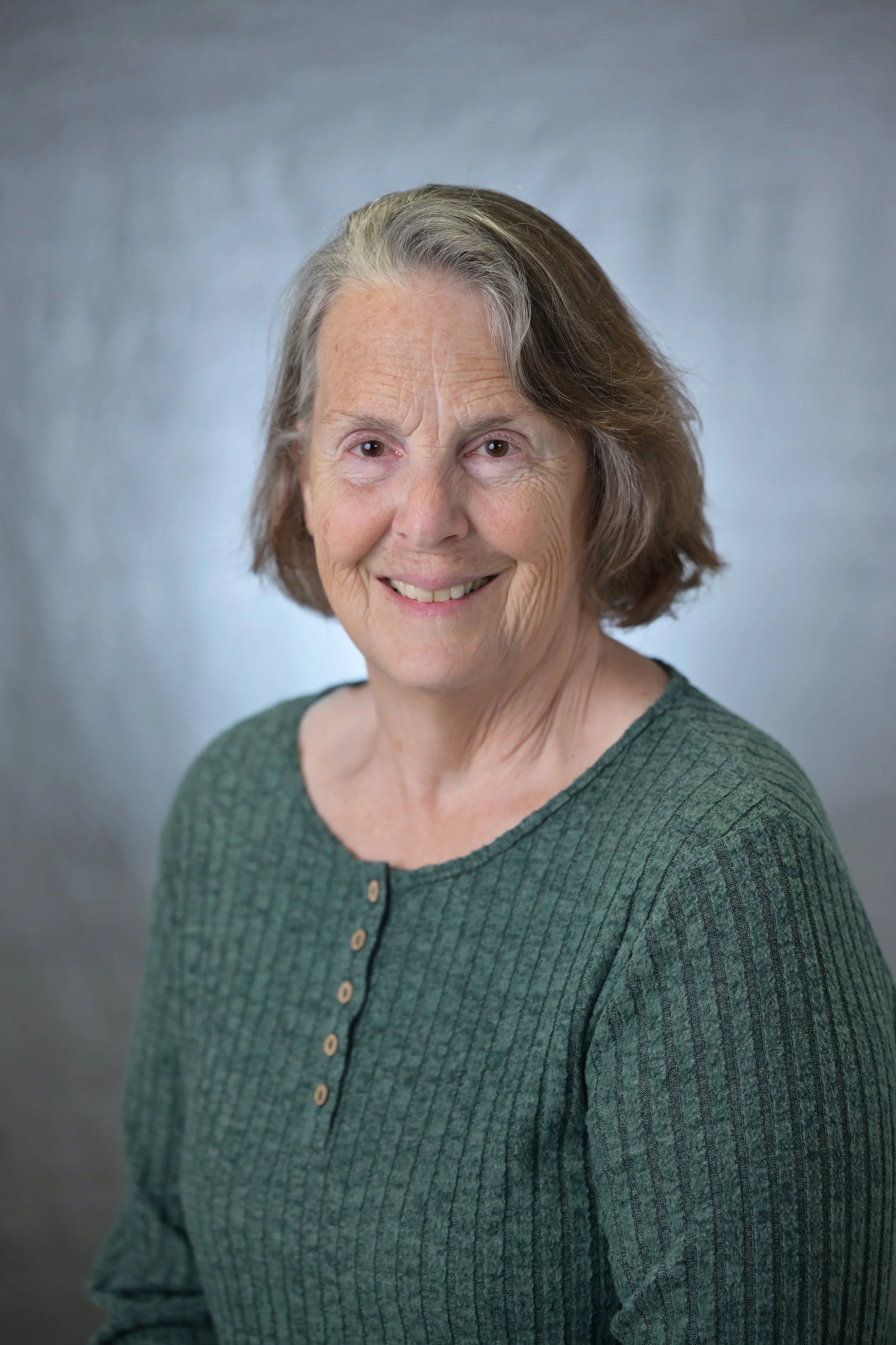 Liz smiling at the camera wearing a green shirt.