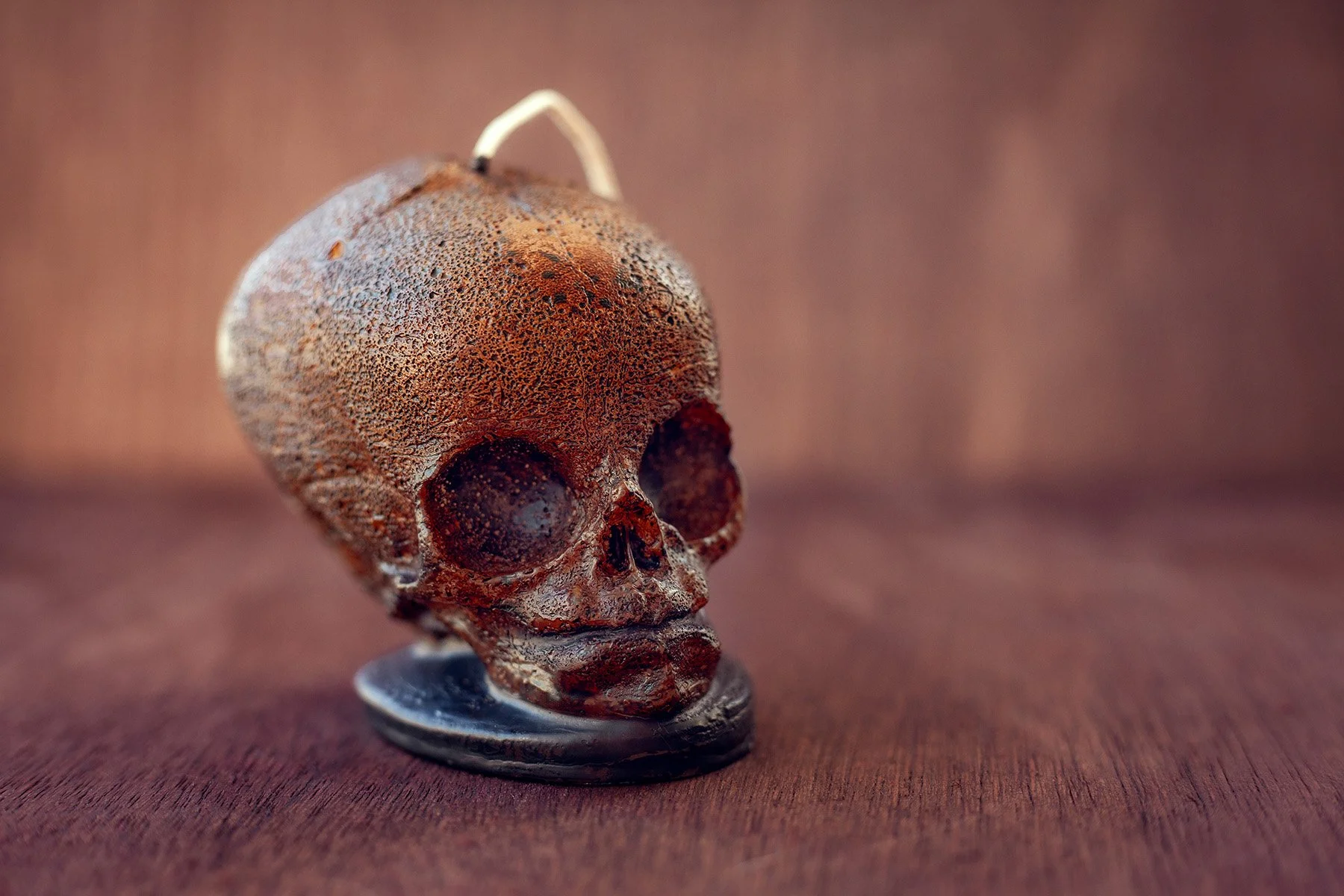 Rusty skull sculpture on a wooden surface.