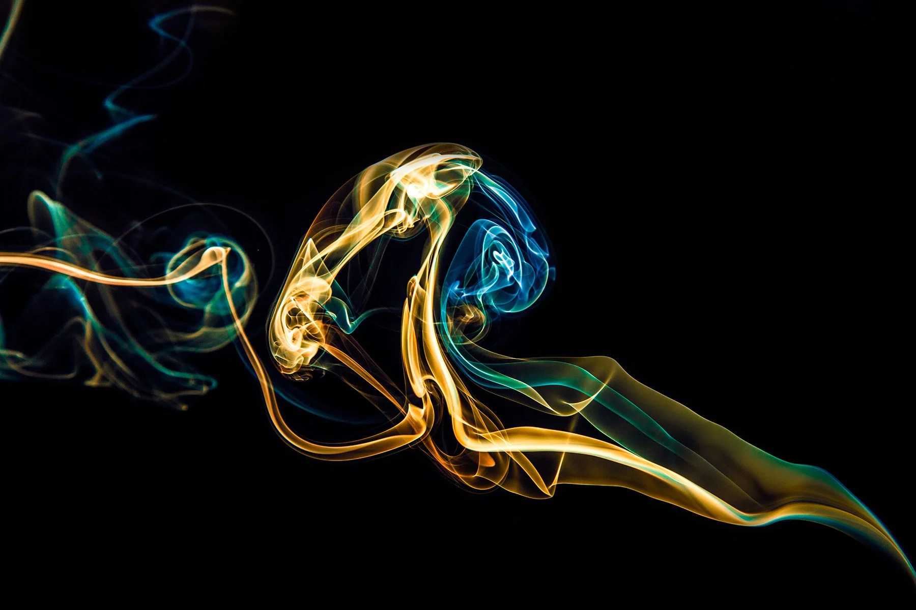 Colorful swirling smoke patterns on a black background