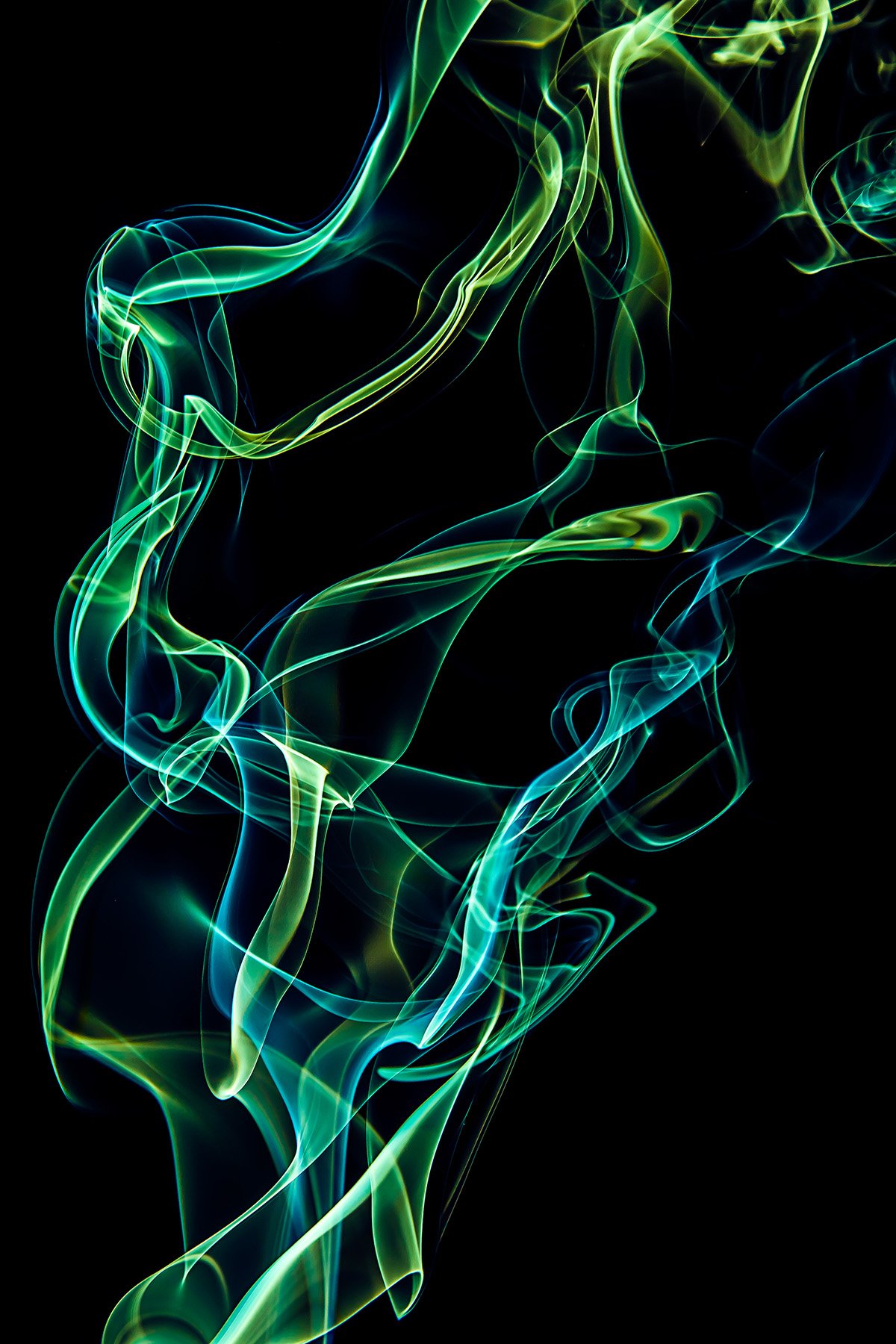 Colorful, swirling smoke or vapor patterns in green, blue, and yellow against a black background.