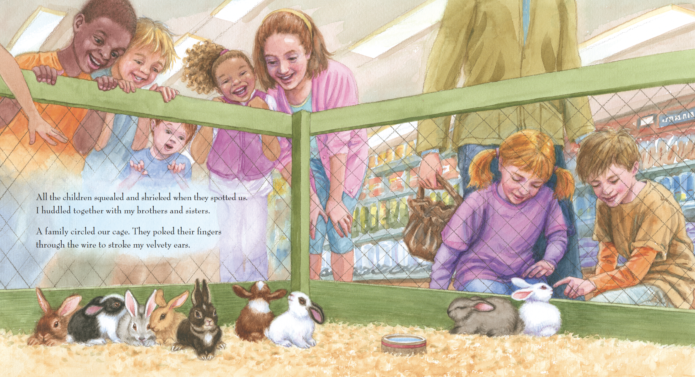 Children and adults at a petting zoo observing rabbits through a wire fence. Some children are leaning over the fence excitedly, while others are inside the enclosure looking at the rabbits, which are sitting on hay. The background shows a grocery st