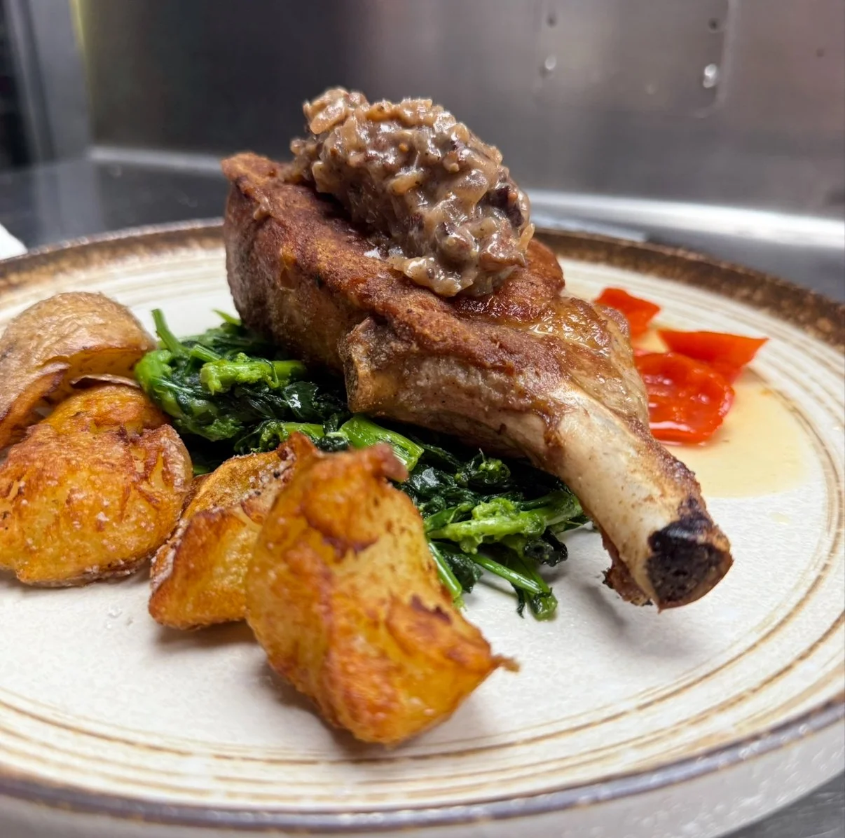 Our pork chop with pepper agrodolce, broccoli rabe, and crispy potatoes