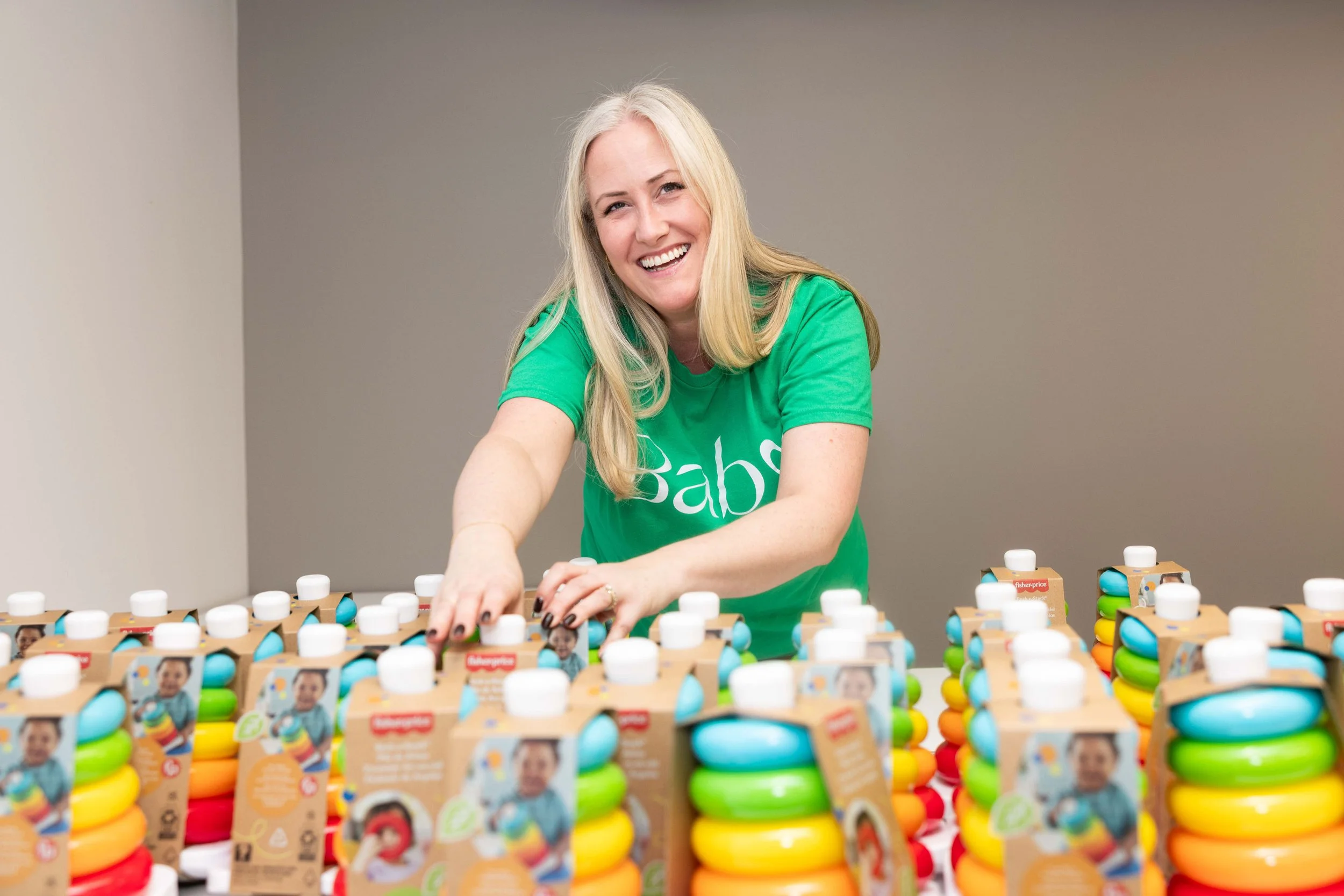 A Baby Love volunteer is shown organizing Rock-a-Stack toys, donated by Fisher-Price towards a packing event