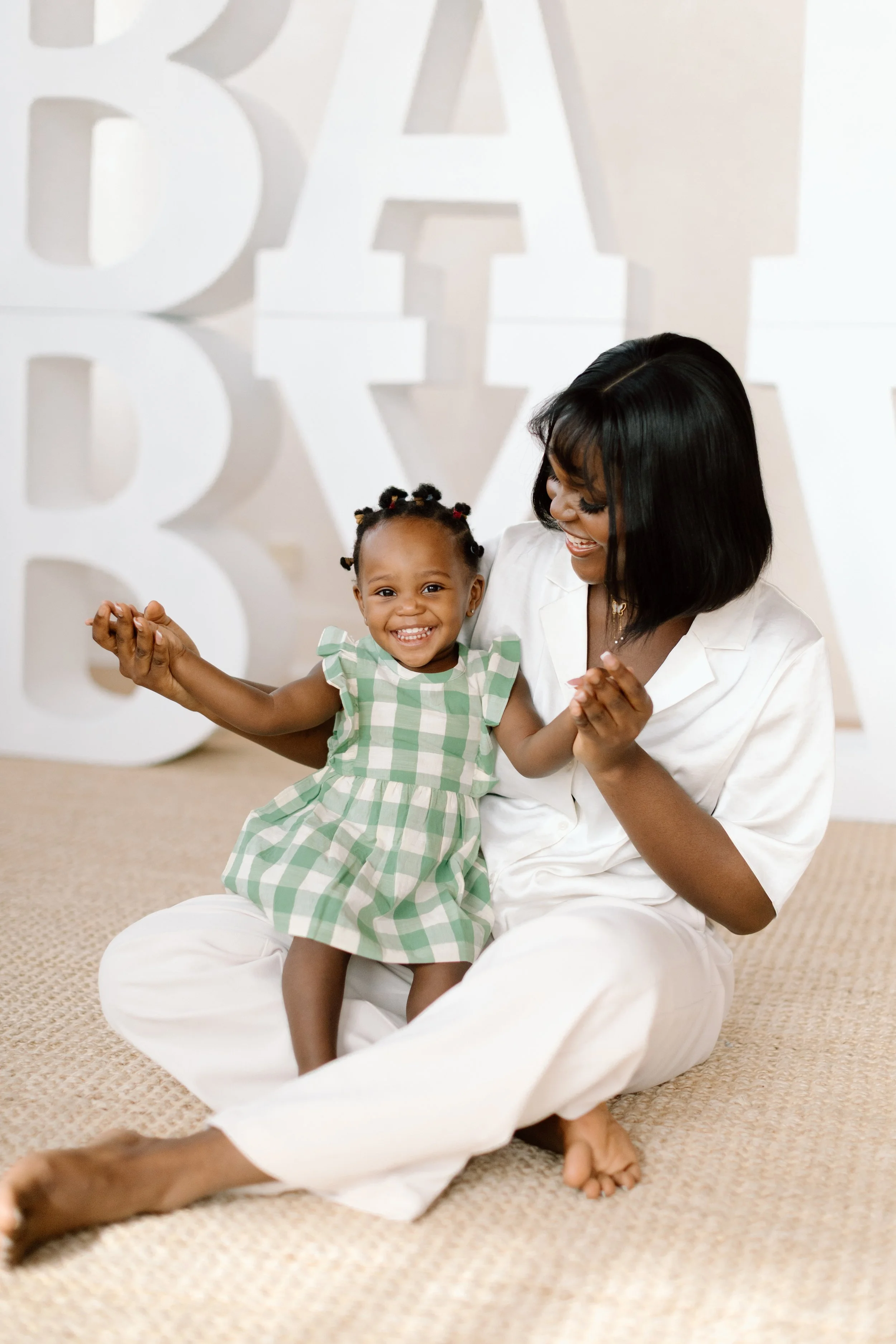 A Baby Love mom, Grace, is shown with her smiling baby, Jasmine