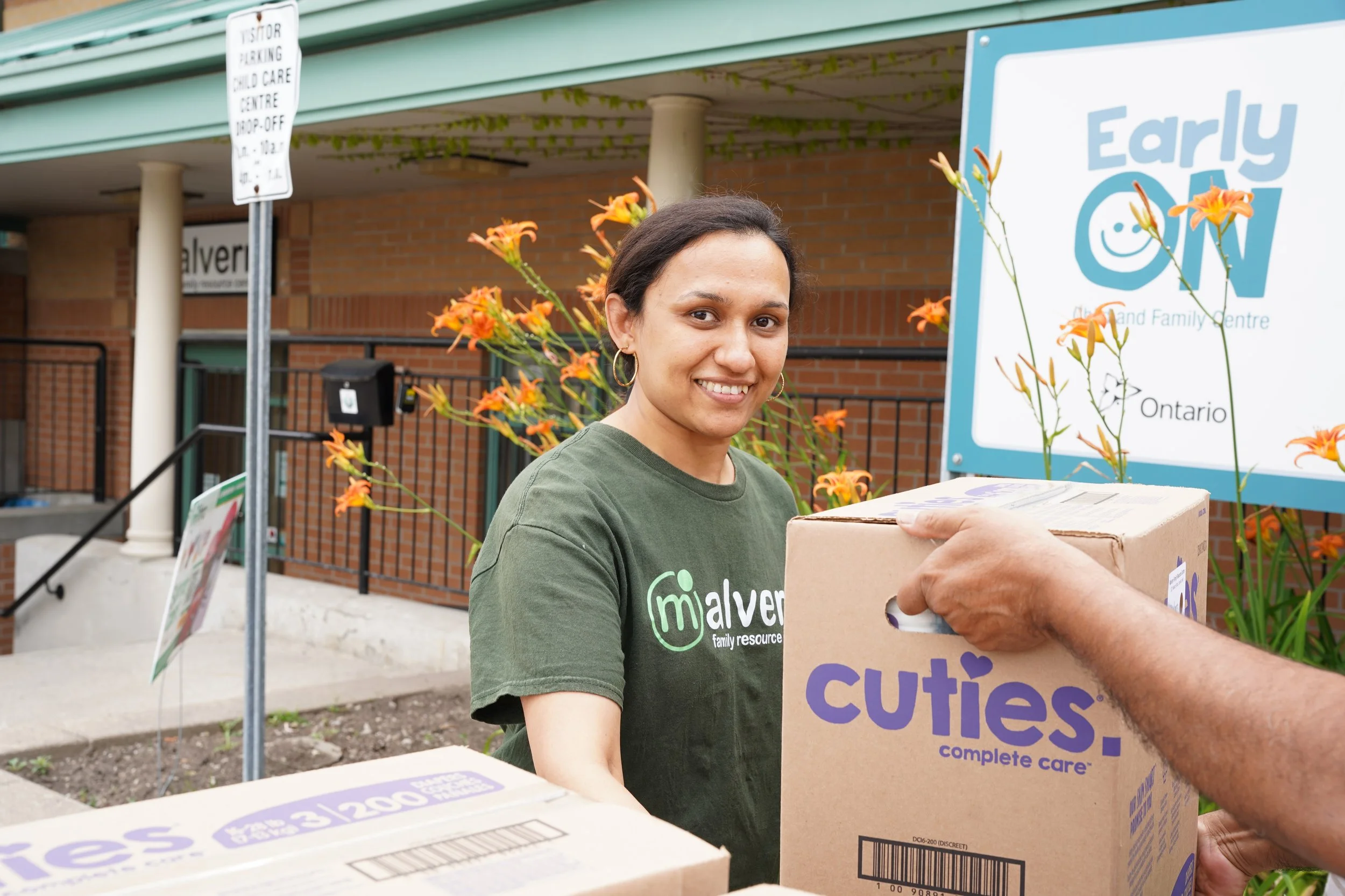 An employee of Malvern Family Resource Centre is shown receiving a Baby Love diaper delivery