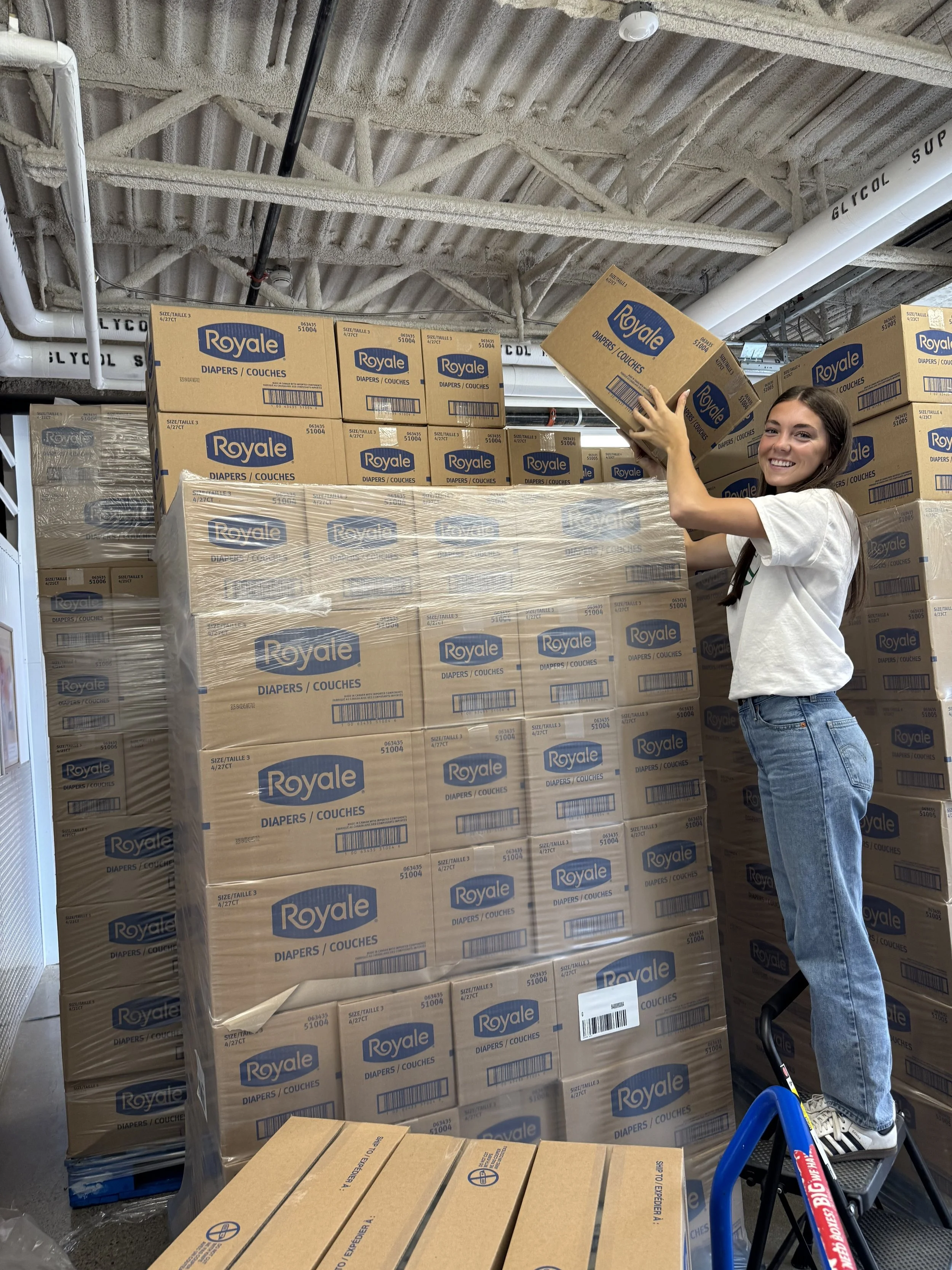 A Baby Love volunteer is shown unpacking Royale diapers