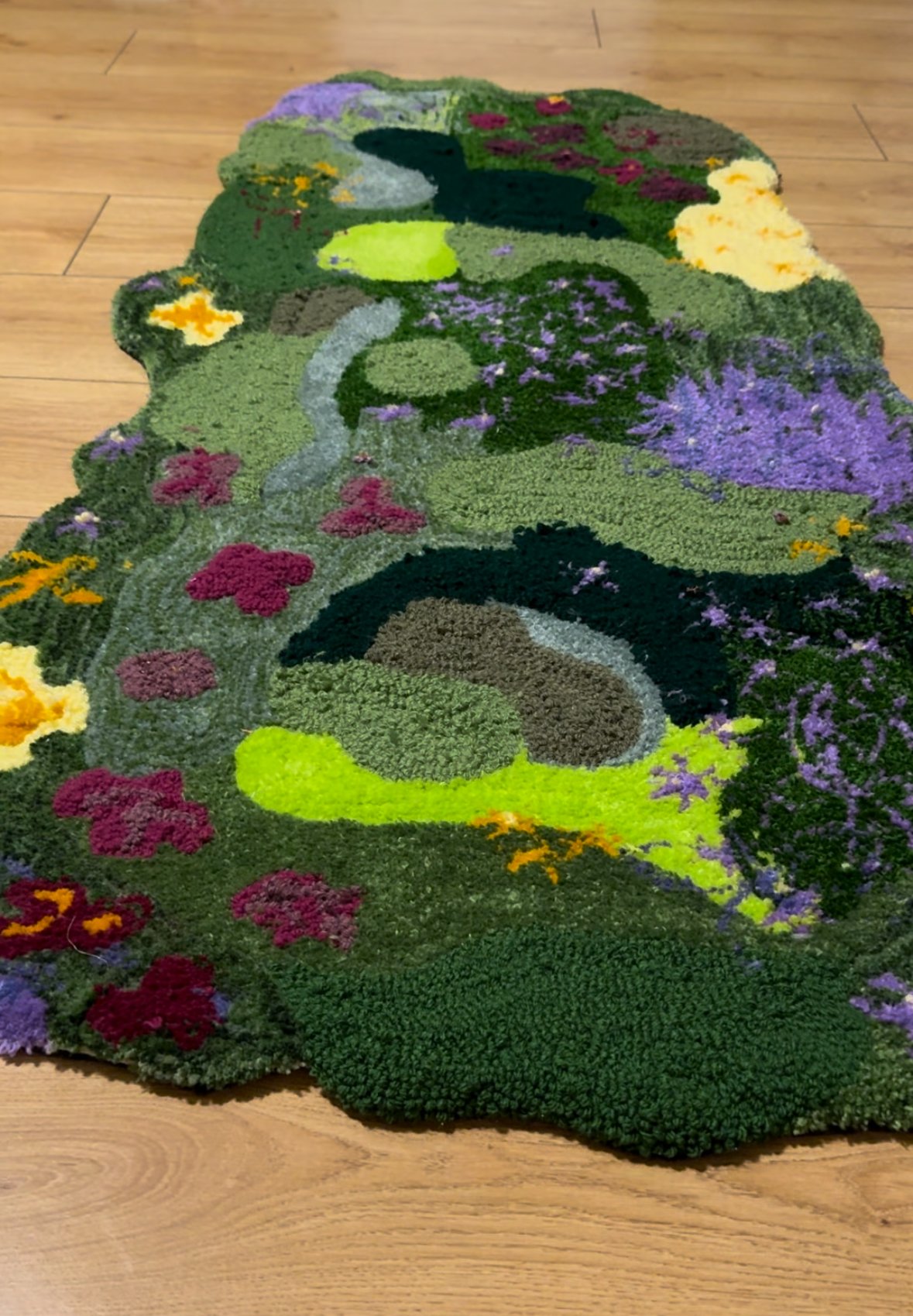 Colorful floral rug with a landscape pattern, placed on a wooden floor