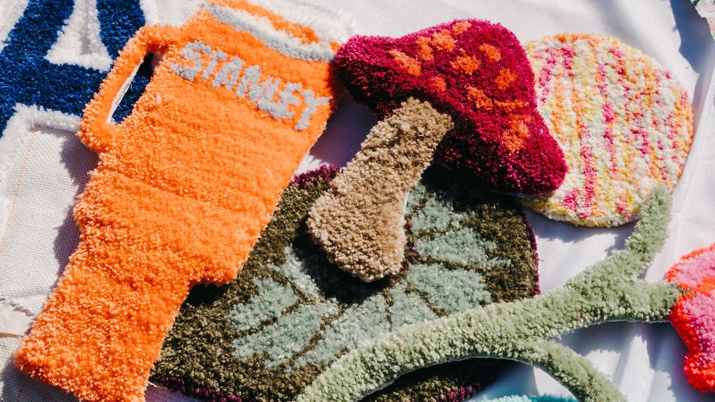 Colorful, fuzzy mats designed to look like various mushrooms on a white surface.
