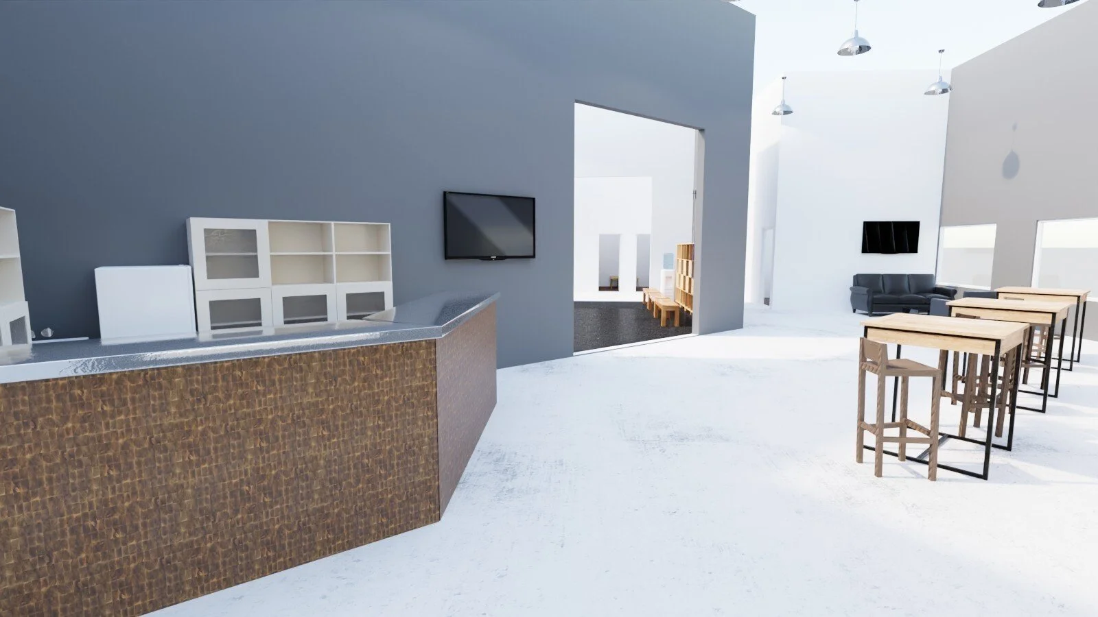 Modern interior space featuring a kitchen counter with brown textured front, gray countertop, and white shelving unit. In the background, there is a living area with white walls, black sofa, and wall-mounted TV. Adjacent room has seating with wooden tables and stools, bright natural light, and minimal decor.