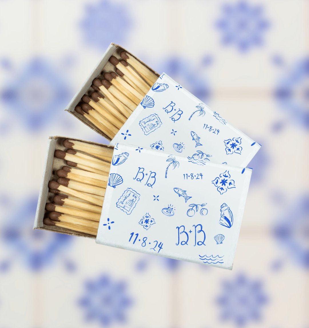 Two open boxes of matches with a paper cover featuring blue beach-themed doodles, including seashells, fish, palm trees, and the date 11-8-24.