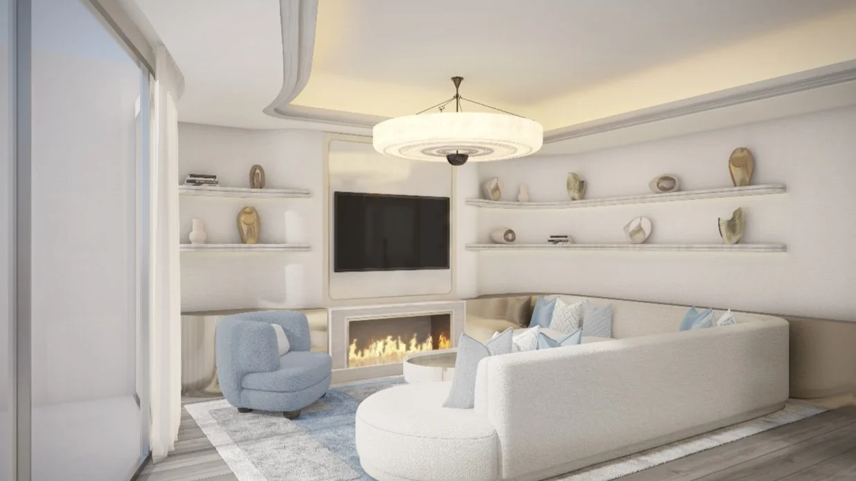 Living room with a large cream sectional sofa, a blue armchair, a flat-screen TV, a fireplace, a circular coffee table, and wall-mounted shelves with decorative vases and books, all under a modern chandelier.