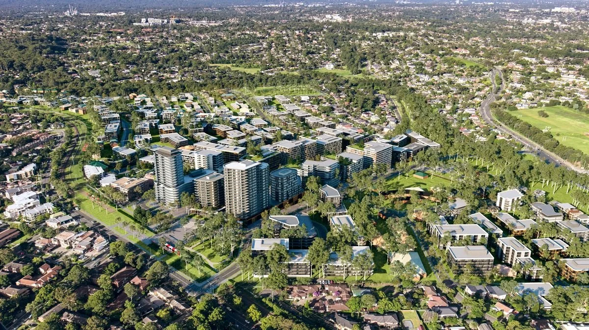 Aerial view of a modern urban development with high-rise buildings, residential houses, green parks, and tree-lined streets in a cityscape.