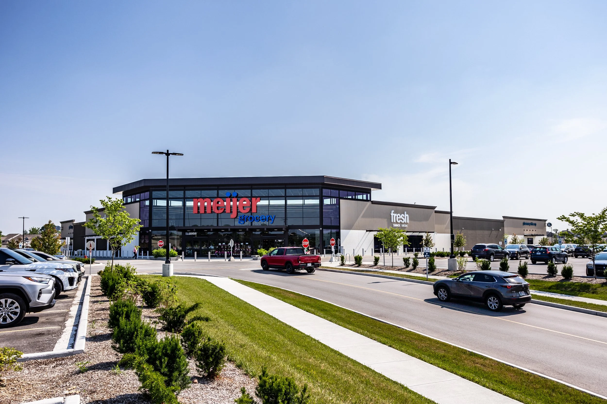 Exterior view of a Meijer grocery store with a parking lot and cars in front and surrounding the store.