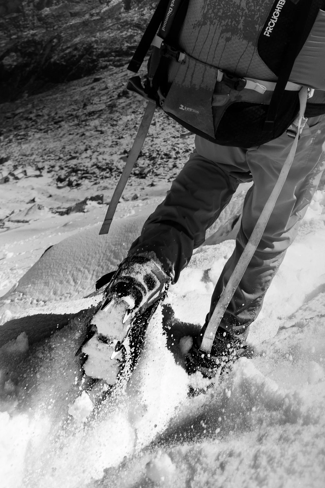 A person snowboarding in the snow-covered mountains, wearing winter gear and holding a snowboard.