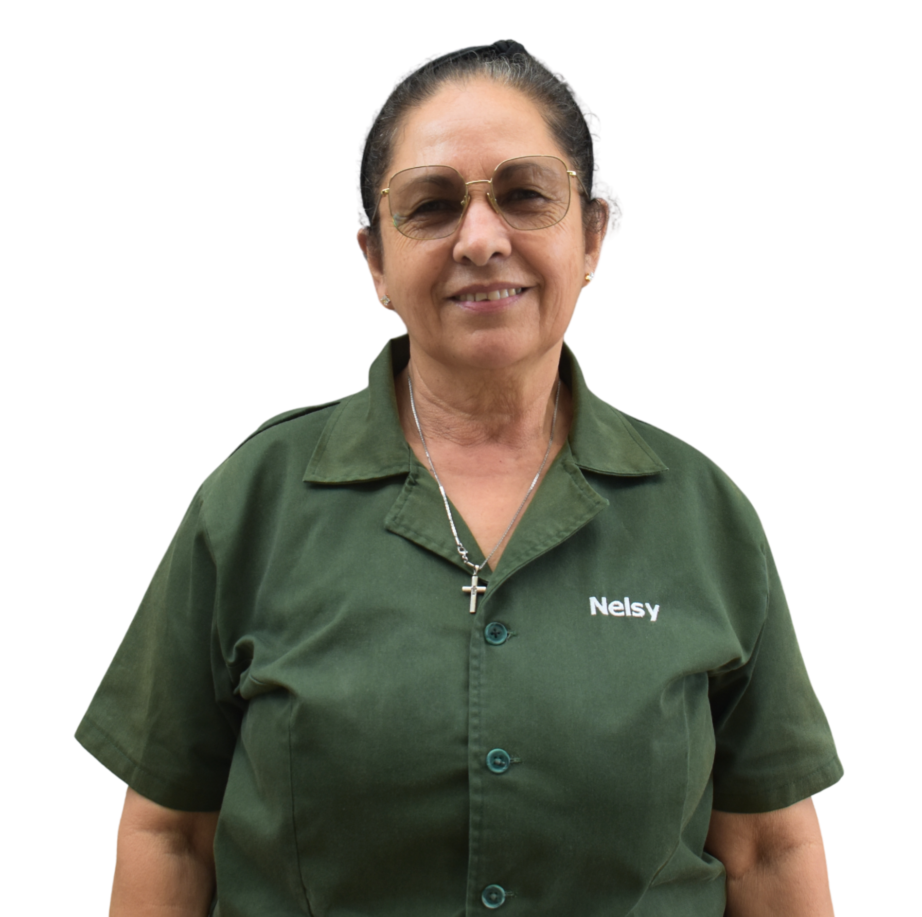 A woman wearing sunglasses, a green uniform shirt with the name 'Nelsy' embroidered on it, and a cross necklace, smiling and standing outdoors.