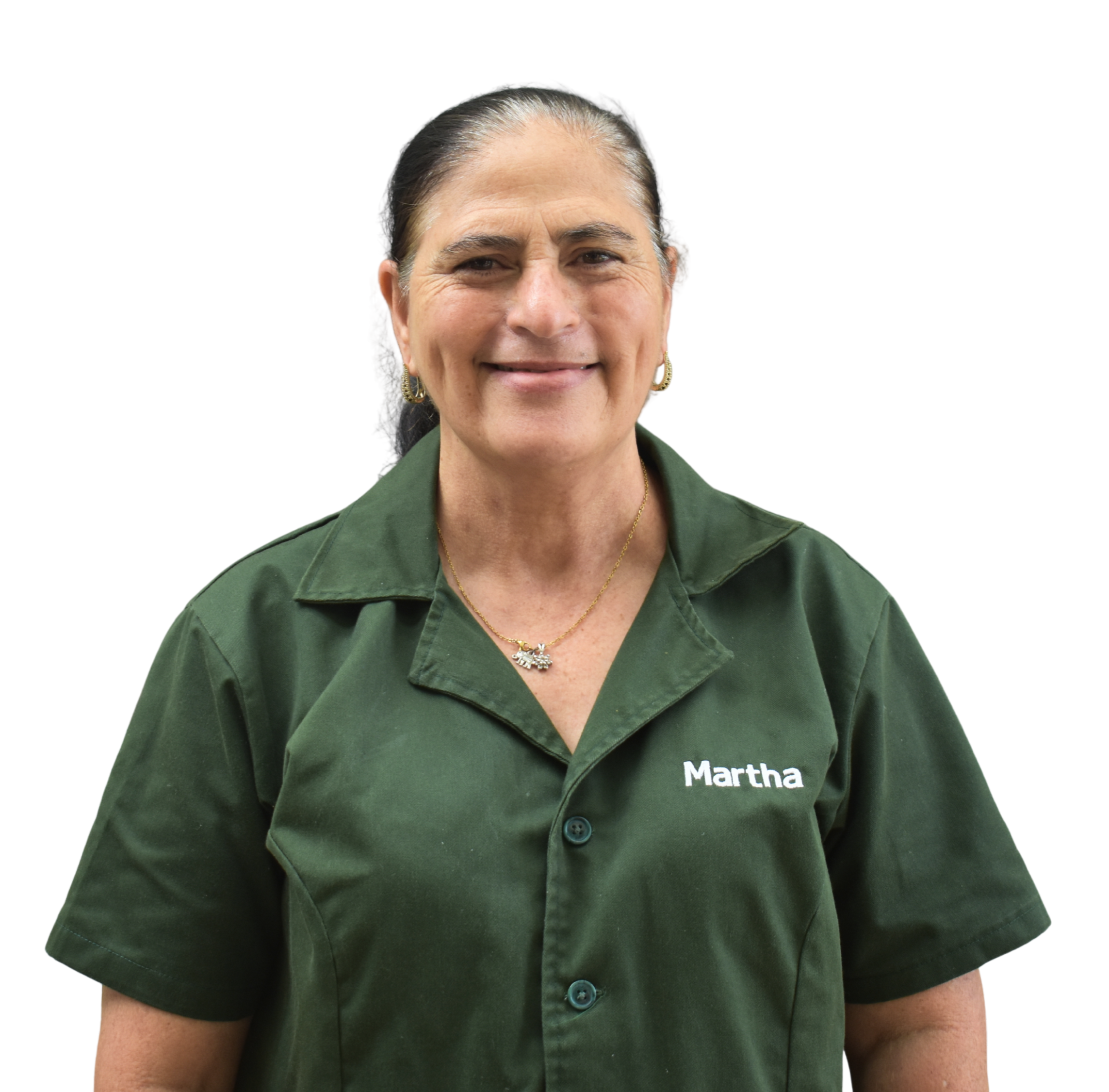 A woman with dark hair, wearing a green shirt with the name 'Martha' embroidered on it, smiling at the camera.