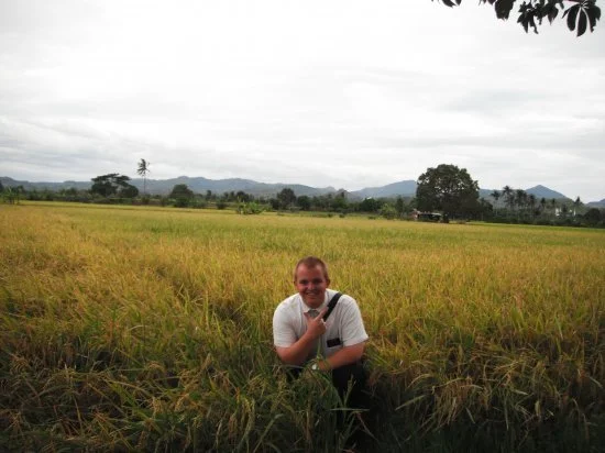 Giles in a rice field as a missionary in the Philippines