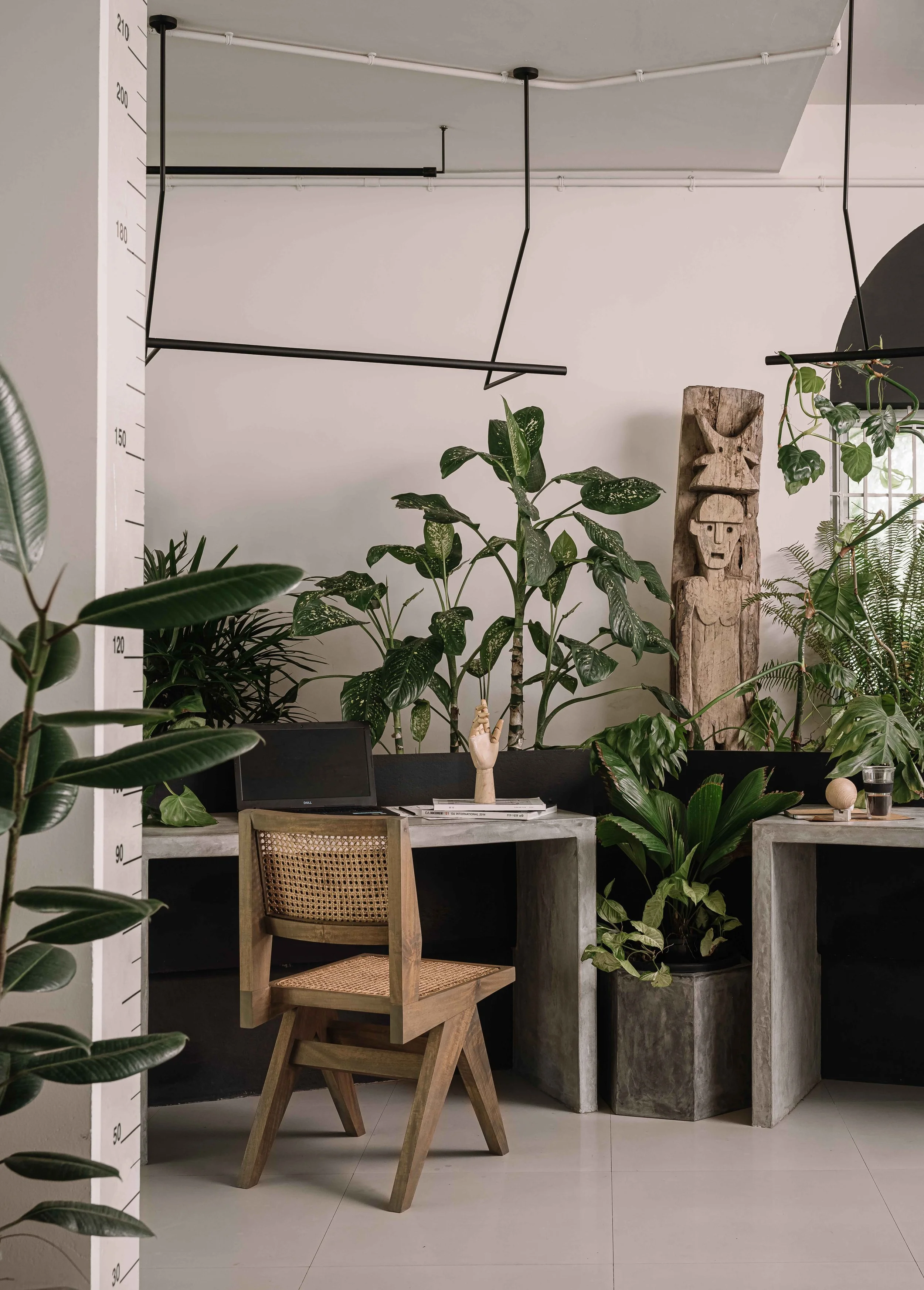 Office workspace at Second Home by Workers of Art featuring handcrafted furniture, lush indoor plants, and contemporary office interiors in Kochi, India.