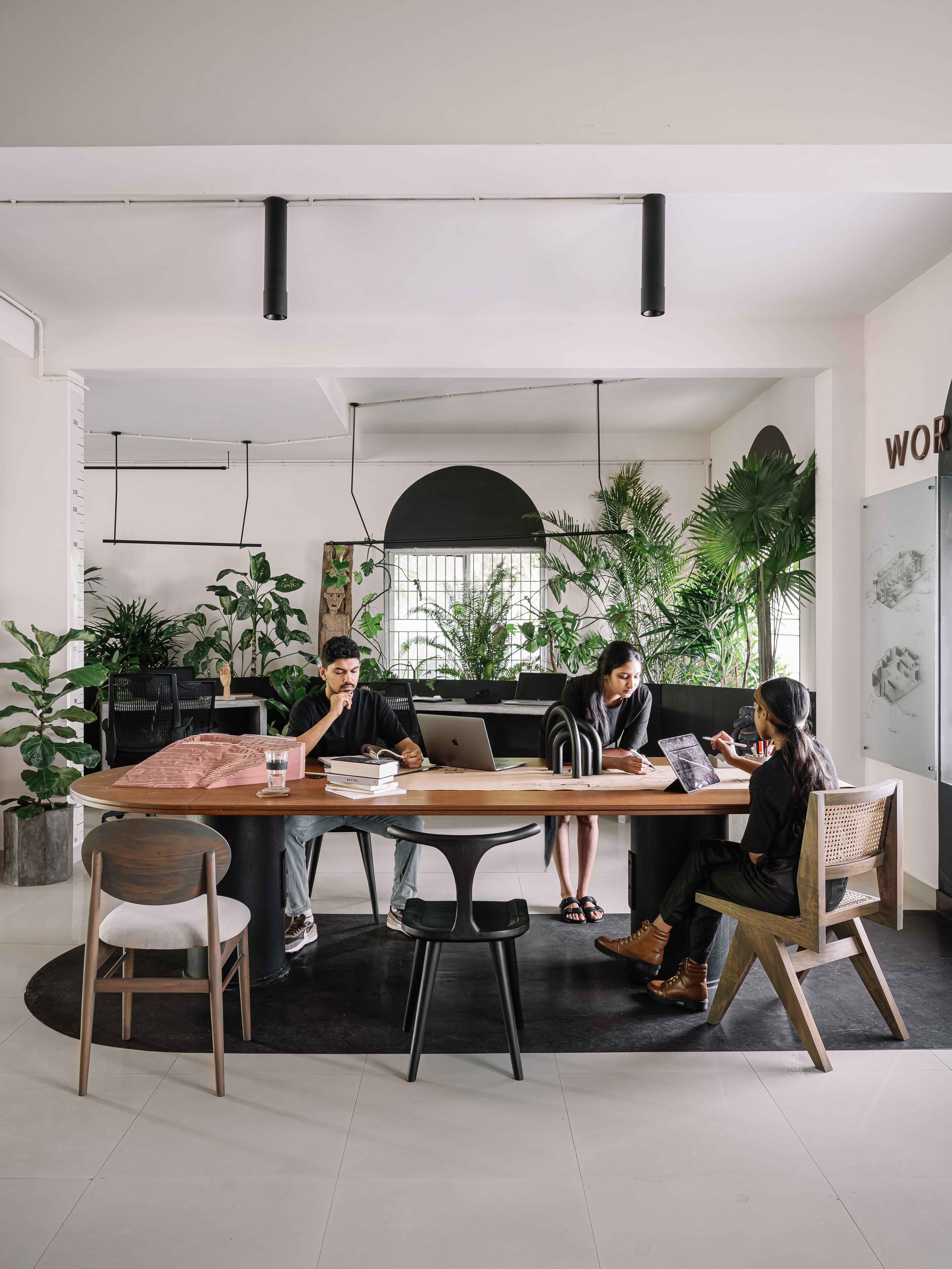 Collaborative workspace at Second Home by Workers of Art featuring a custom meeting table, biophilic office interiors, and team collaboration in Kochi, India.