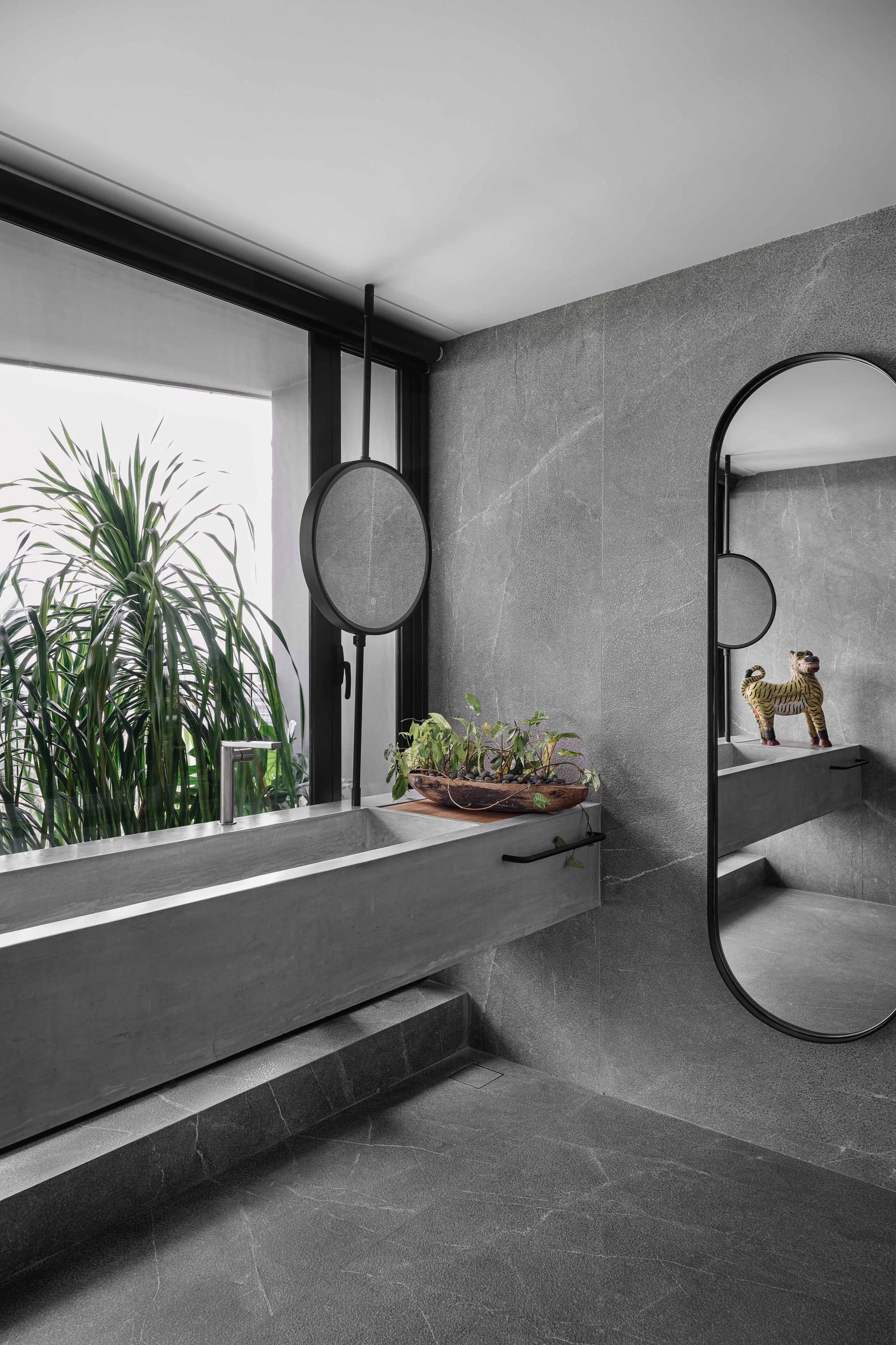 The master bathroom features a custom ferrocement double sink supported by a concealed metal member, allowing natural light to filter from multiple directions and creating the sensation of an open, outdoor-like space.