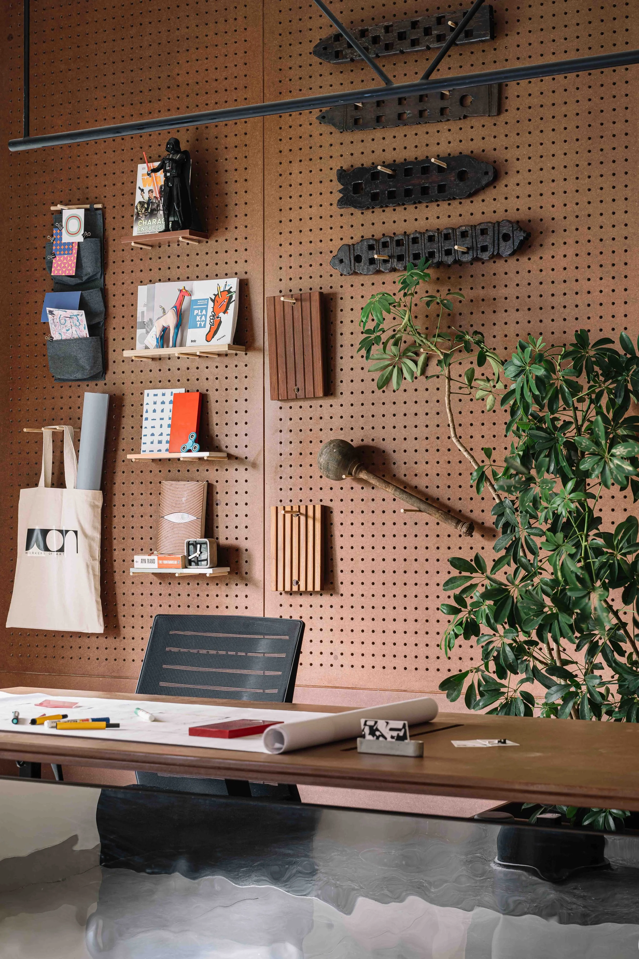 Studio detail at Second Home by Workers of Art featuring a custom pegboard display, handcrafted design objects, and contemporary workspace interiors in Kochi, India.