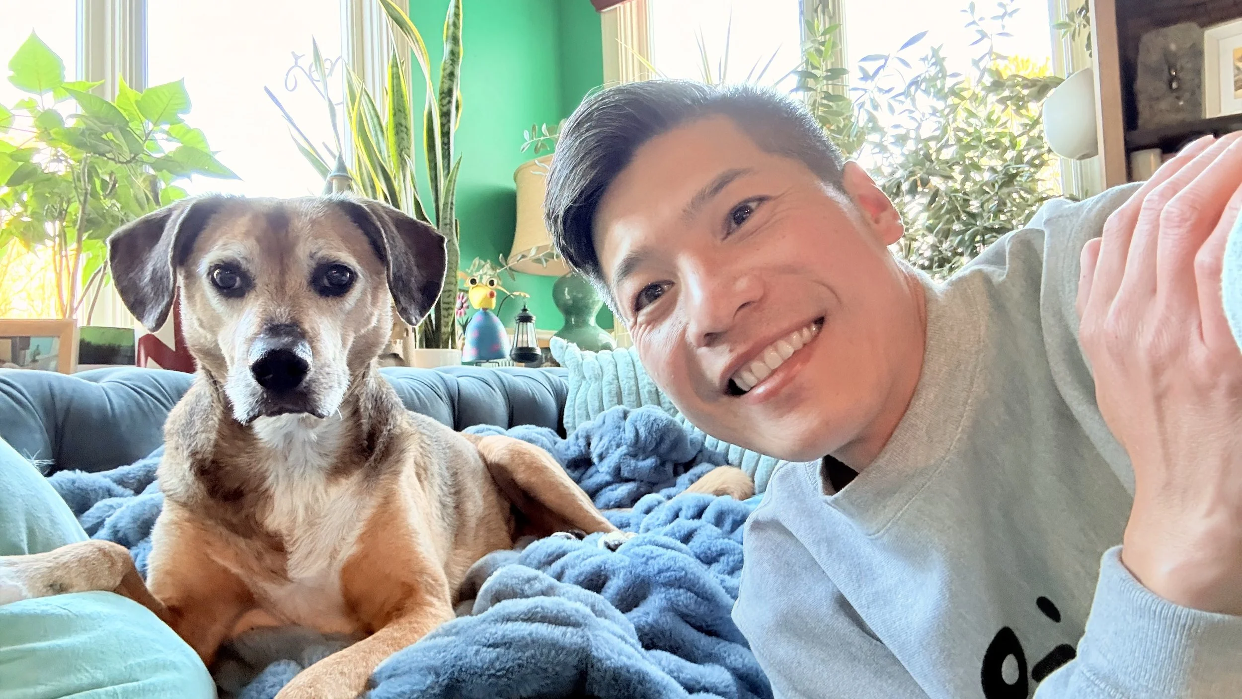 A happy dog walker smiling for a selfie with a dog after a two-week multiple drop-in visits during her parents' vacation. 