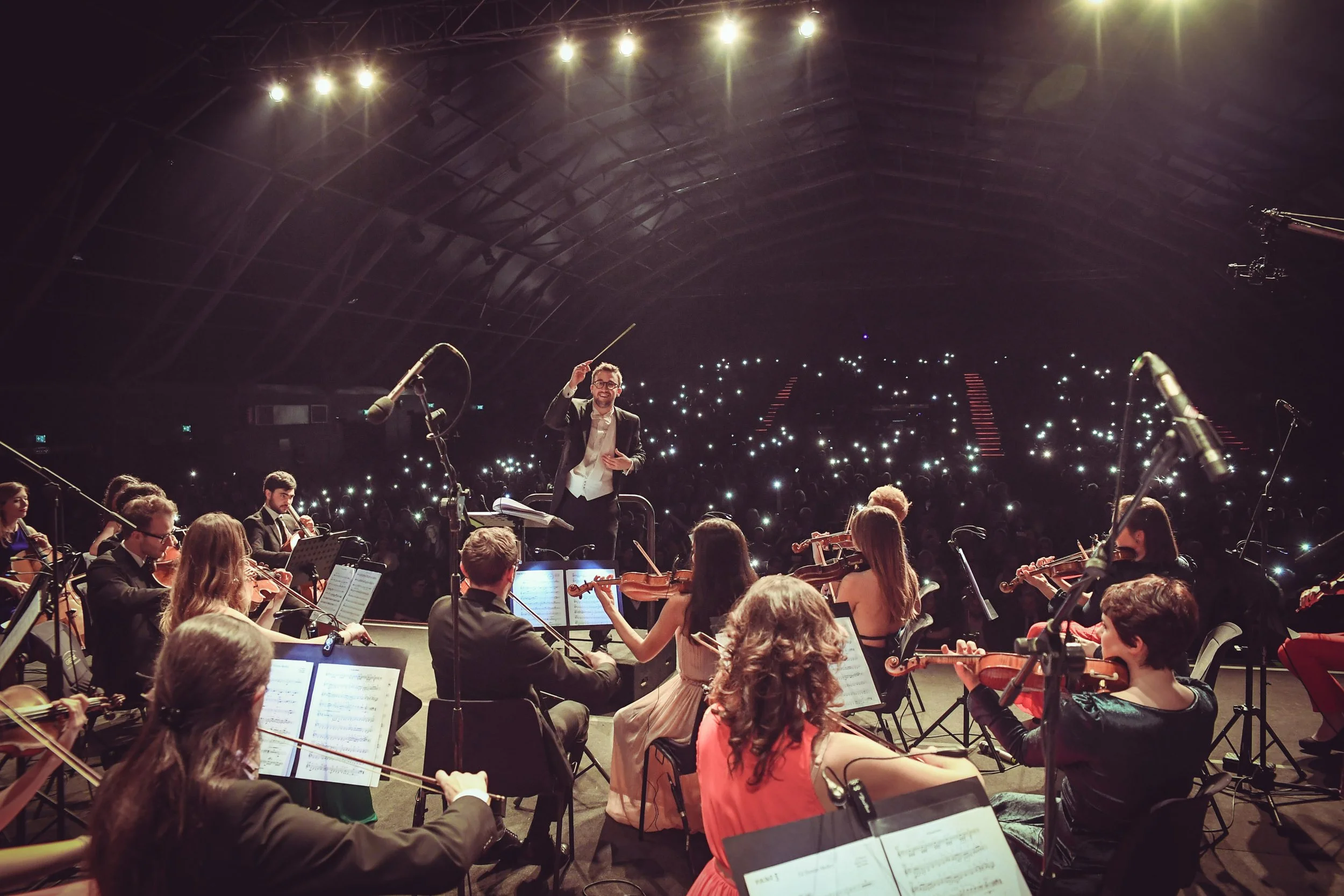 L'orchestra suona sul palco mentre il pubblico del Gran Teatro Geox accende i flash dei cellulari