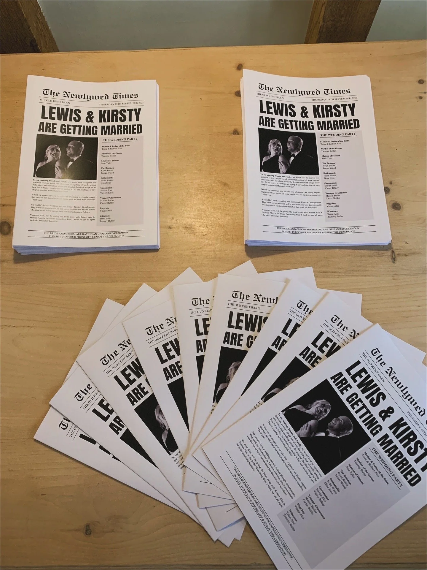 Wedding programs and napkins with a newspaper-style layout announcing Lewis and Kirsty's wedding at The Old Kent Barn.