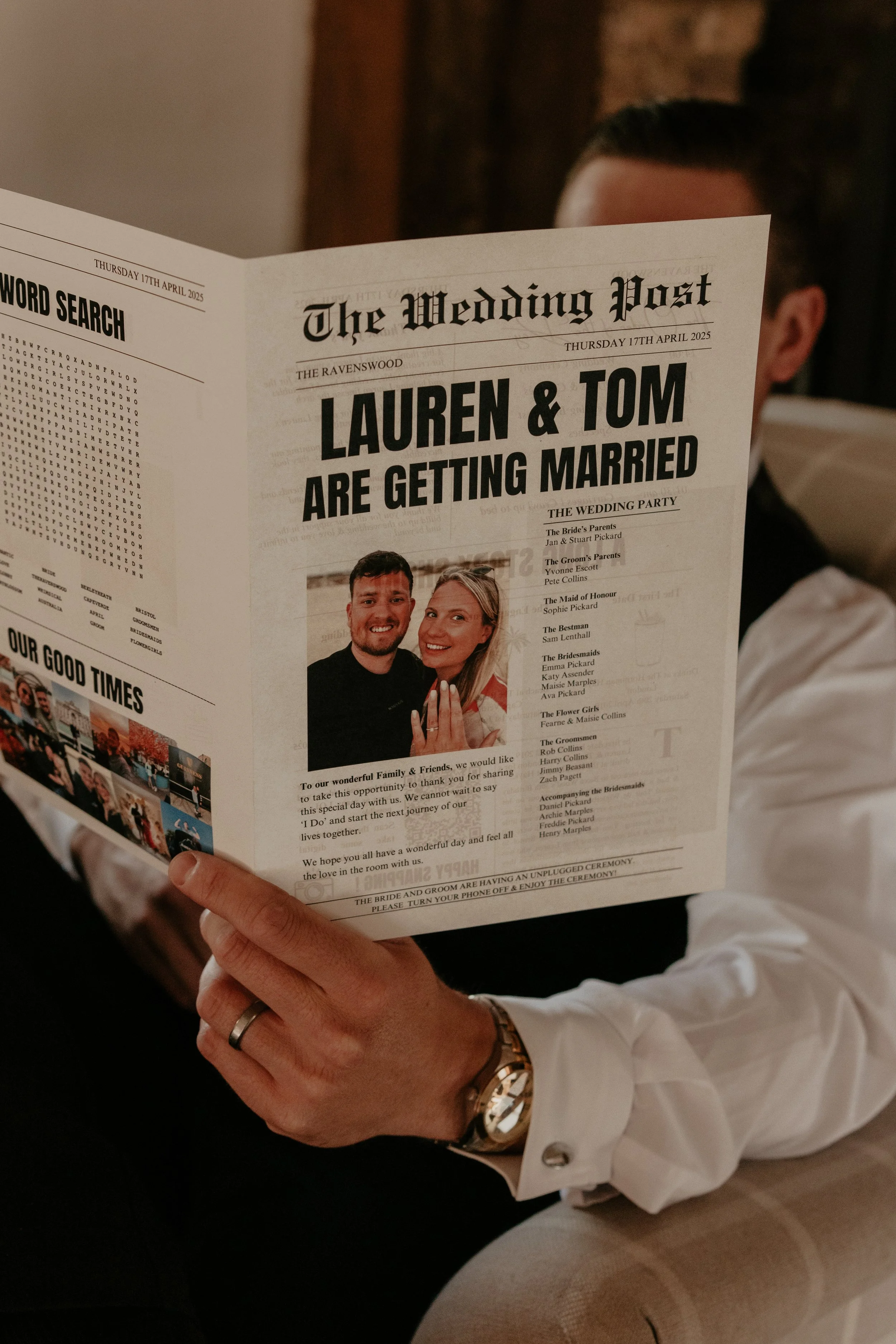 A person reading a wedding day newspaper invitation for Lauren and Tom's wedding, with a photo of the couple smiling, dressed in formal attire, and a wedding schedule printed on the paper.