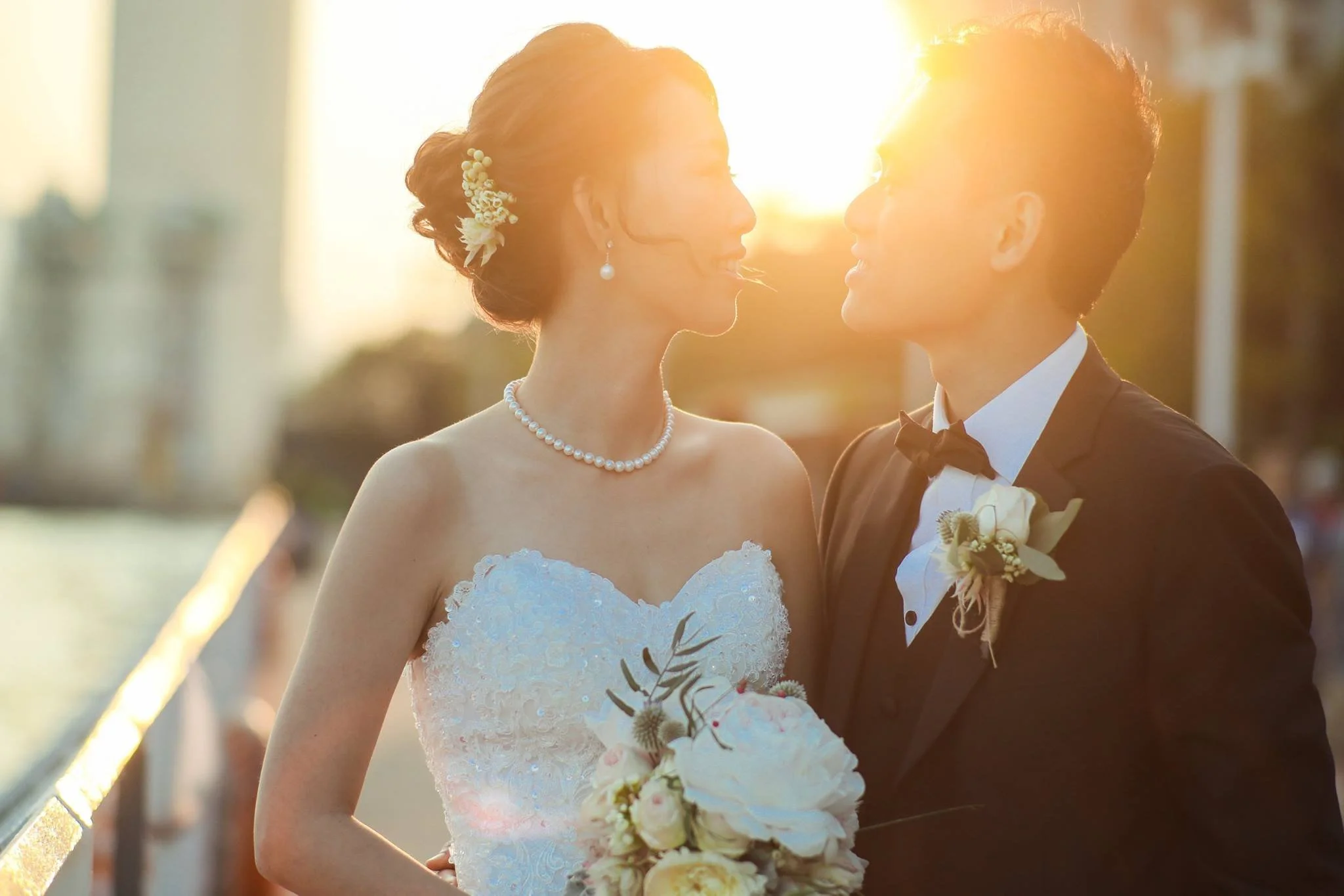 A bride and groom standing close together during sunset, facing each other at their wedding ceremony.