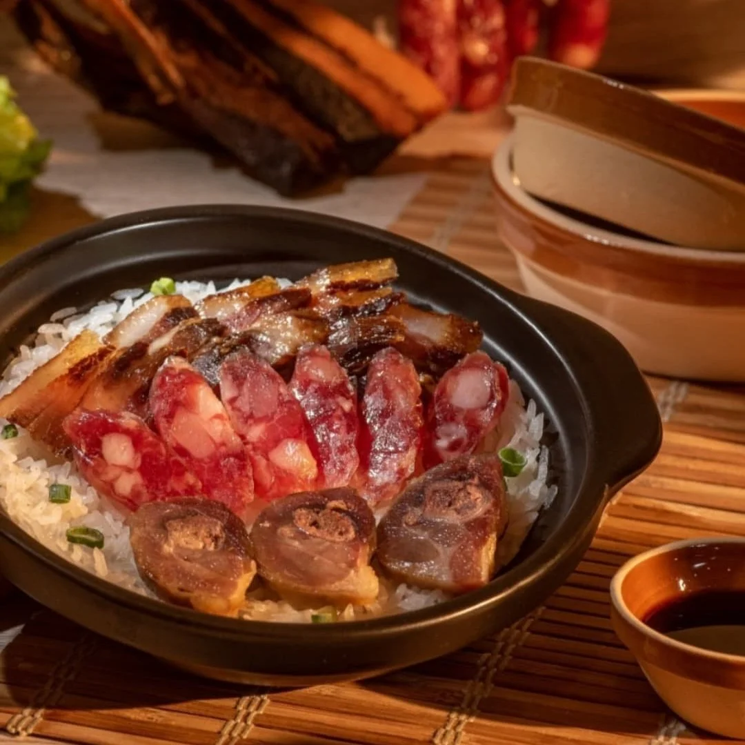 A bowl of Chinese dish with sliced meat, pork, and rice, accompanied by soy sauce.