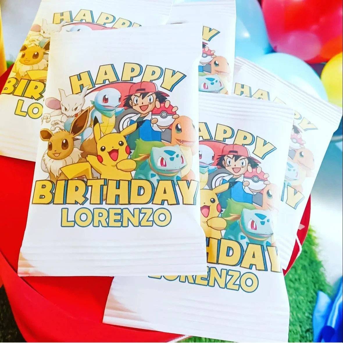 Buste di carta per feste di compleanno con personaggi di Pokémon, con scritto 'Happy Birthday Lorenzo'.
