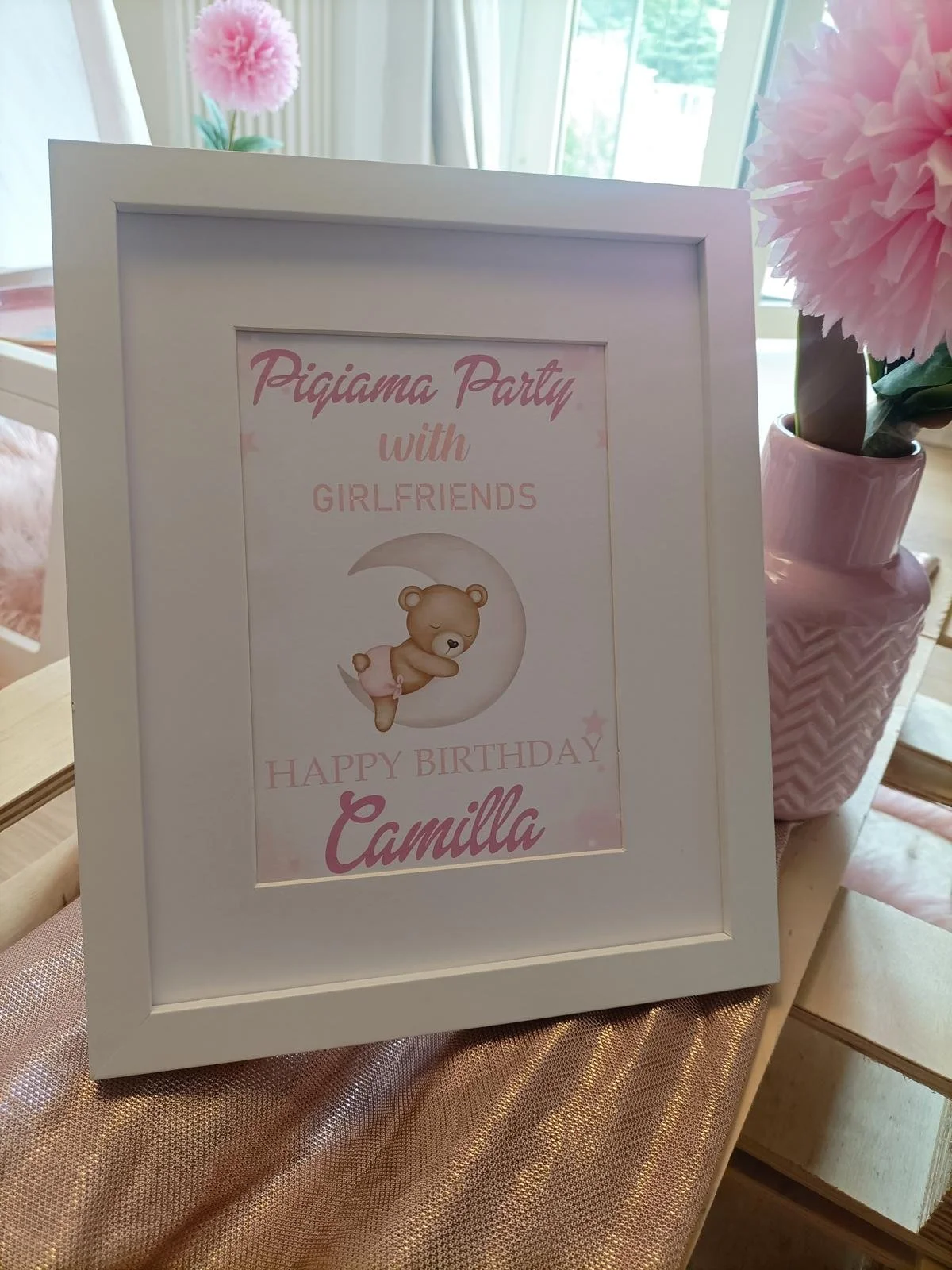 Segnaposto per festa di compleanno con tema pigiama party, con immagine di orsetto e scritte in rosa e bianco.