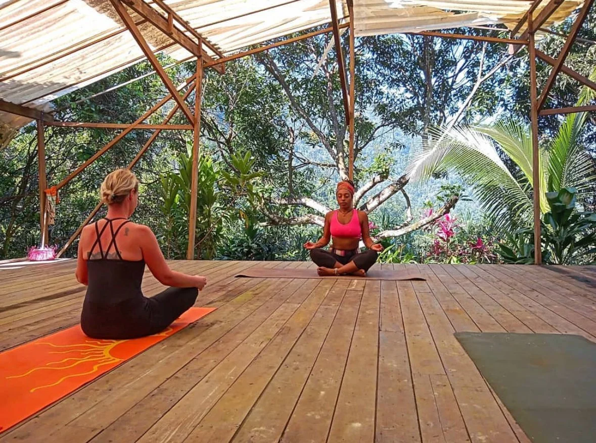 Solstice Rising Co retreat guests practicing yoga in a sacred open-air space above the Cangrejal Valley