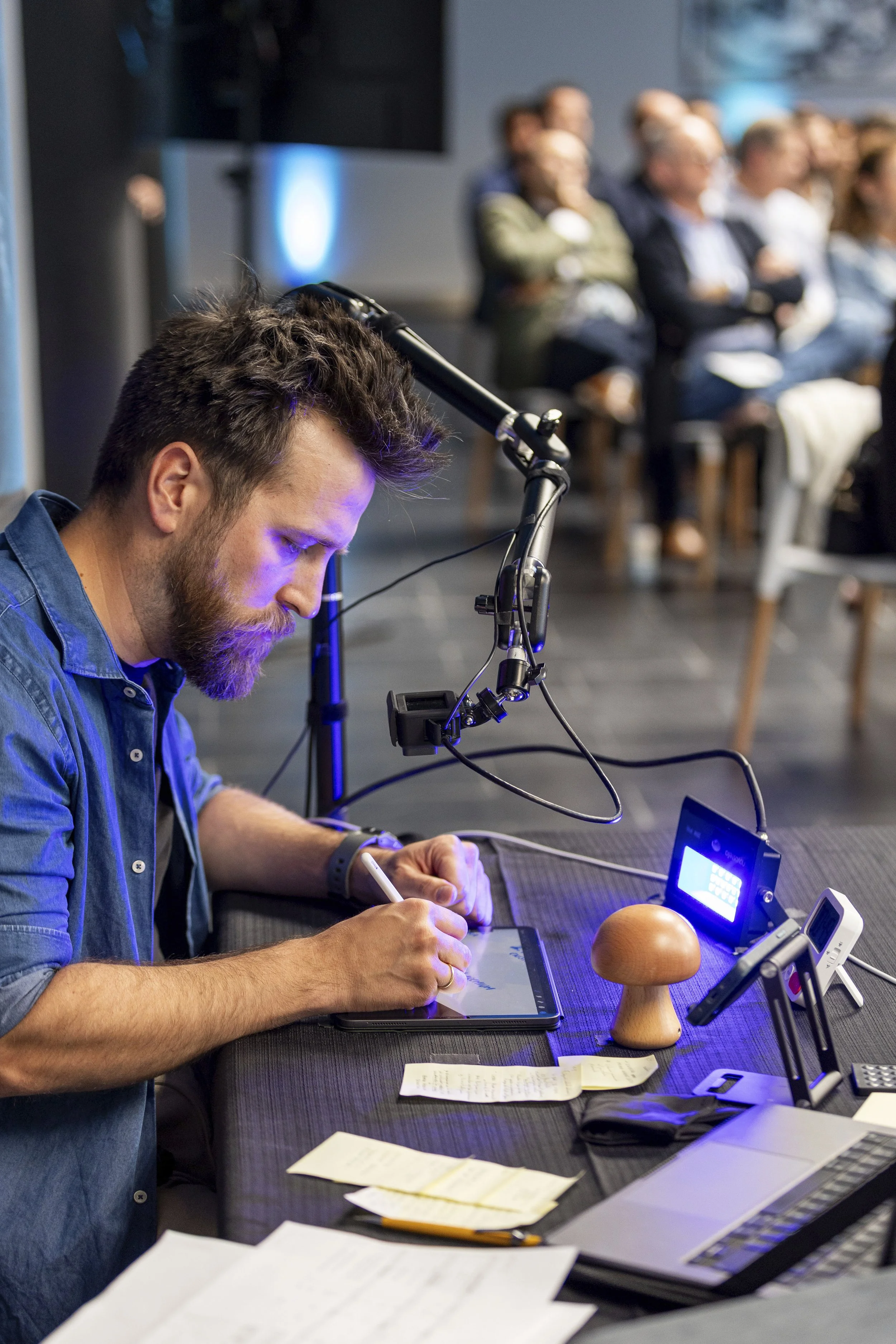 Hombre con barba trabajando en un iPad haciendo Visual Thinking en un evento frente a una audiencia