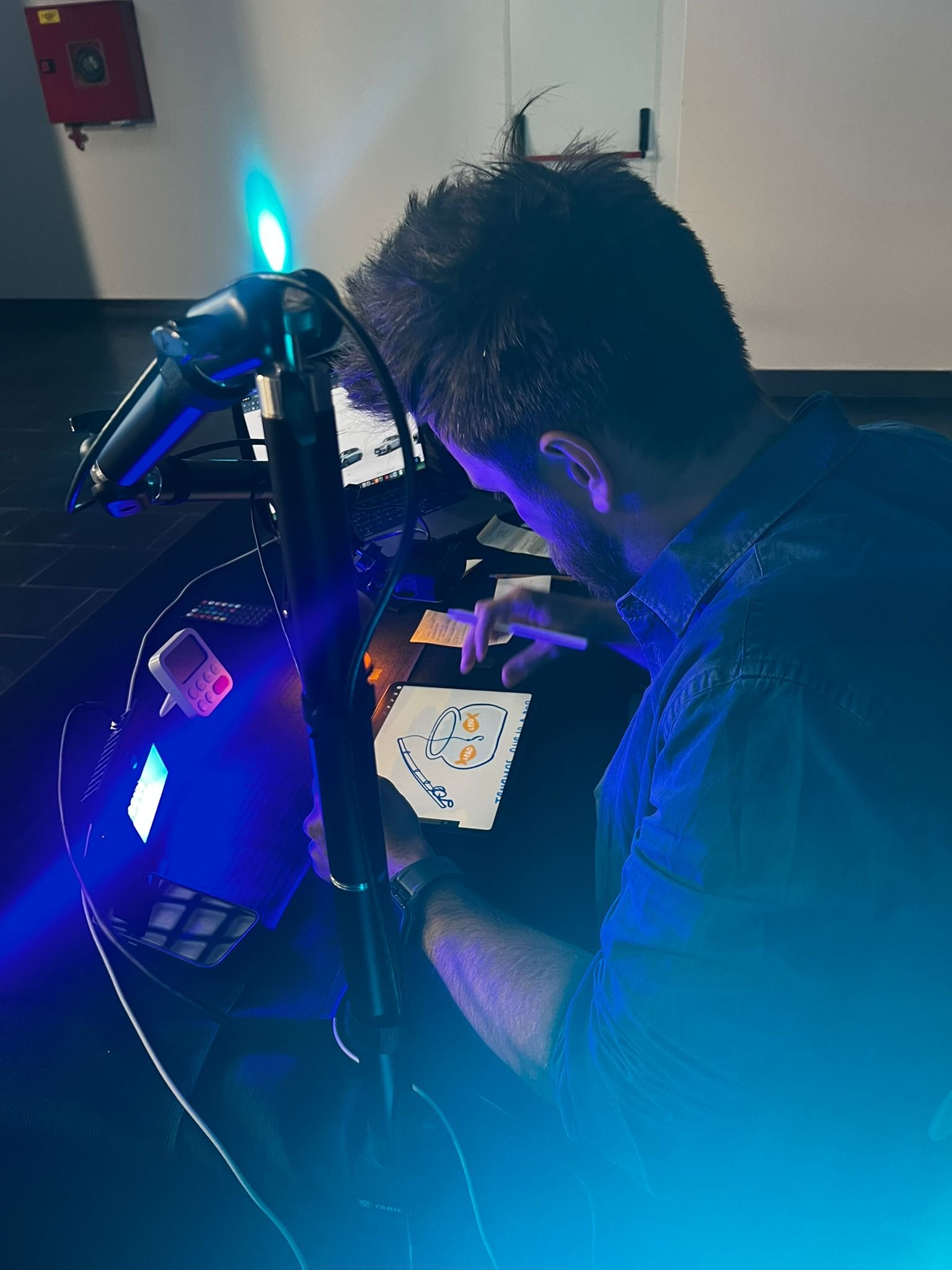 Un hombre usando un bolígrafo digital y un iPad ilustrando con Visual Thinking en un evento.