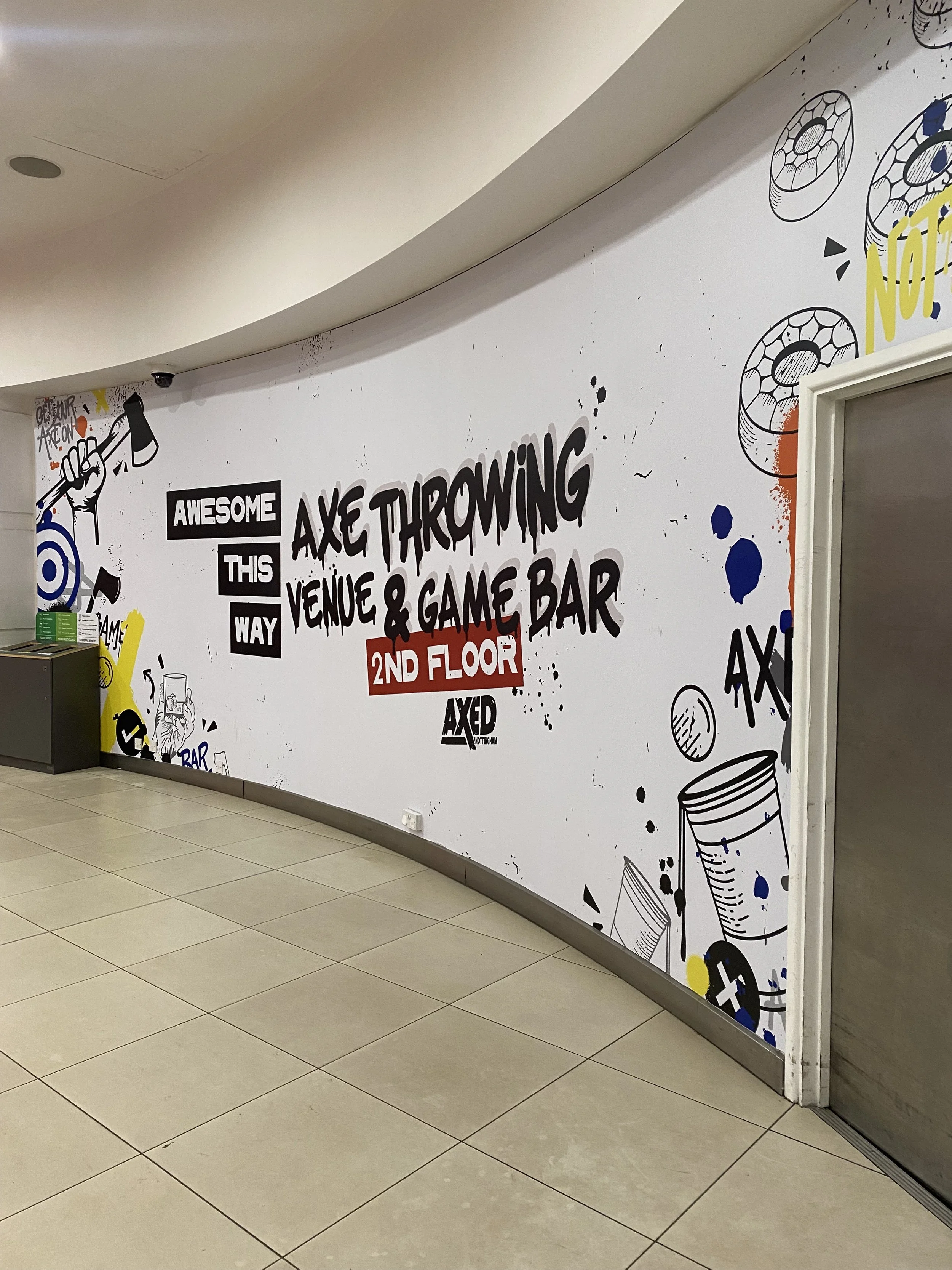 A real life image of a large scale wall advertisement in The Cornerhouse Nottingham for the Axed Nottingham Venue. Designed and executed by Rogue State