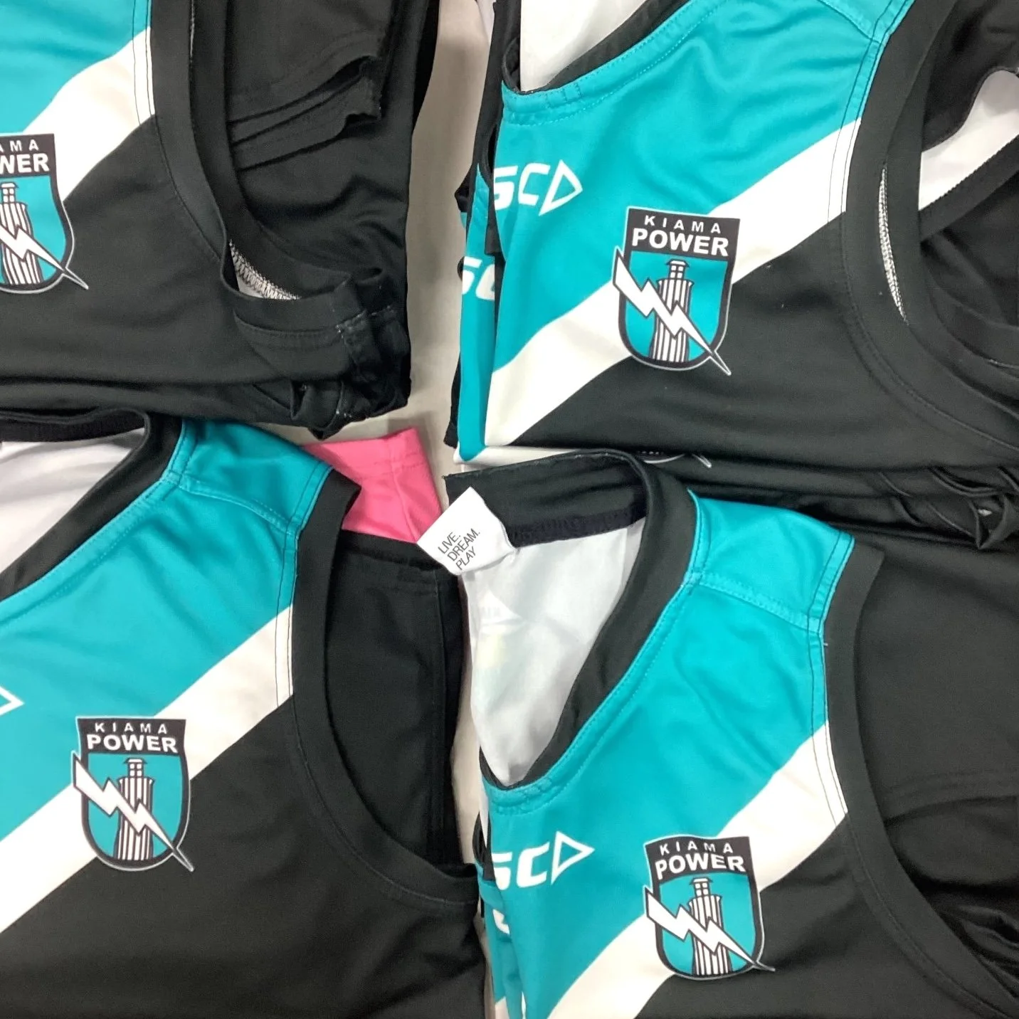 Multiple sports jerseys and shirts with the Kiama Power Australian Rules Football logo.