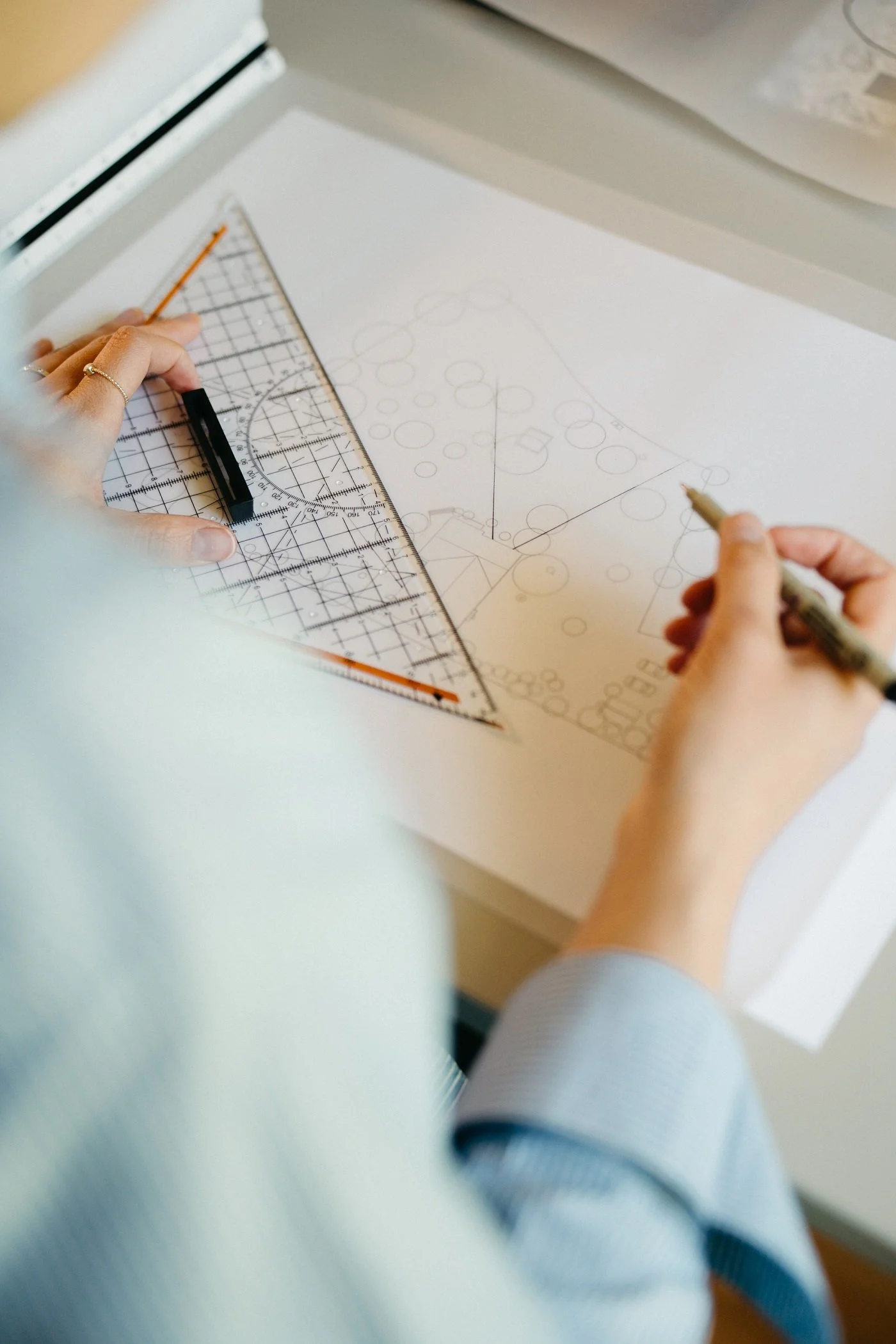 Close-up van vrouw van Studio Jong Baw die zichtlijnen tekent op papier met een potlood voor een tuinontwerp voor een ecologische tuin, voor een landschapstuin in Zweden