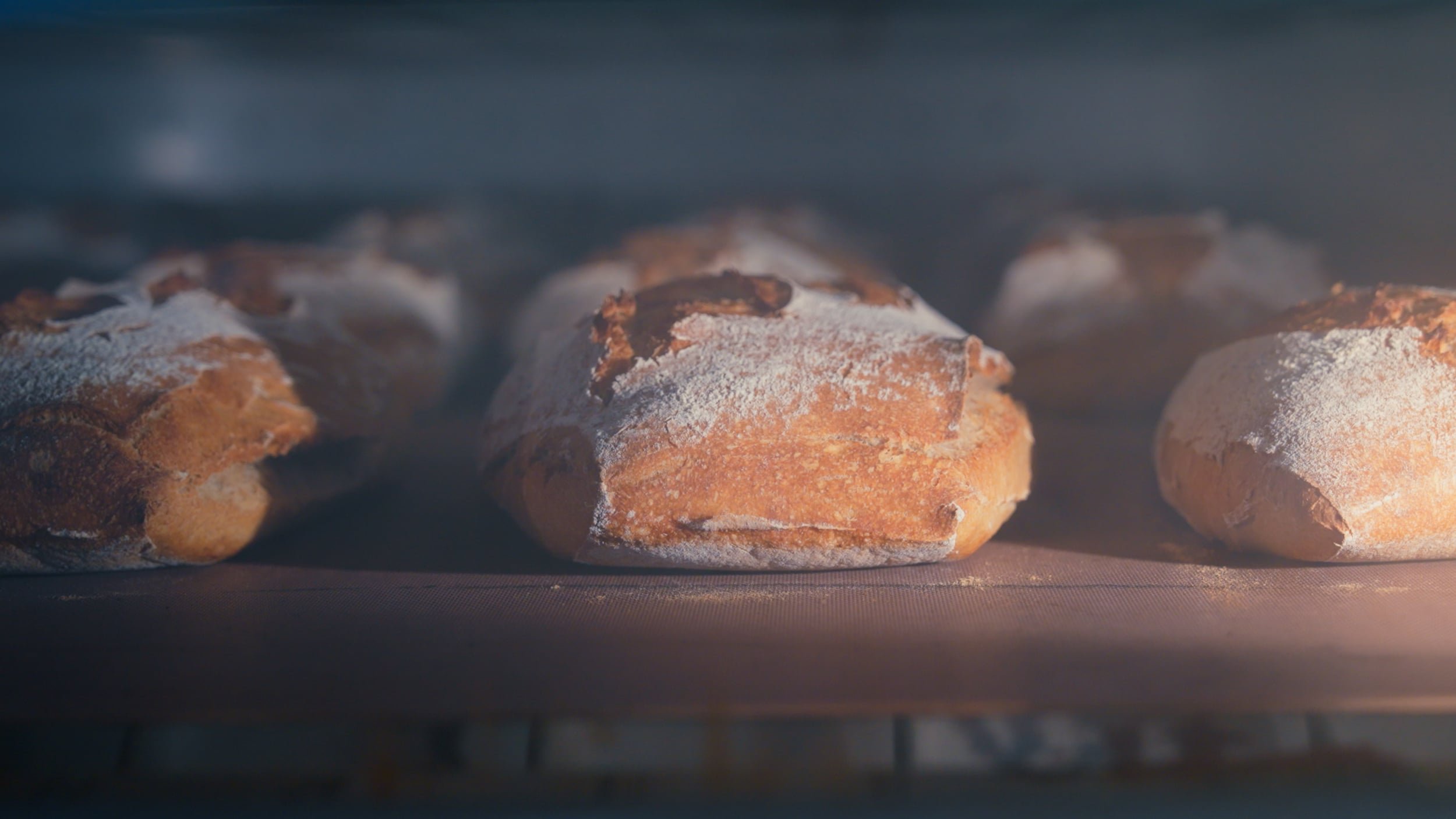 Trois pains à la farine avec une croûte dorée, cuits au four, sortie du four