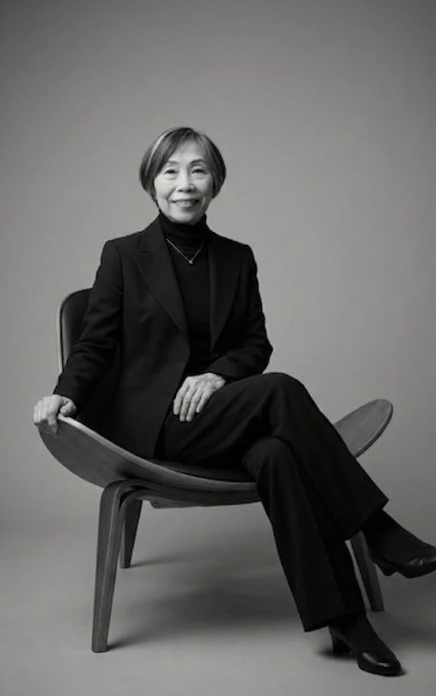 卓越した技能で独自の世界観を創り出す、高級フラワーブランド「MASAKO MODESTE（マサコモデスト）」のトップデザイナー、高松雅子の公式プロフィール写真。モダンな椅子に腰掛ける白黒のポートレート。